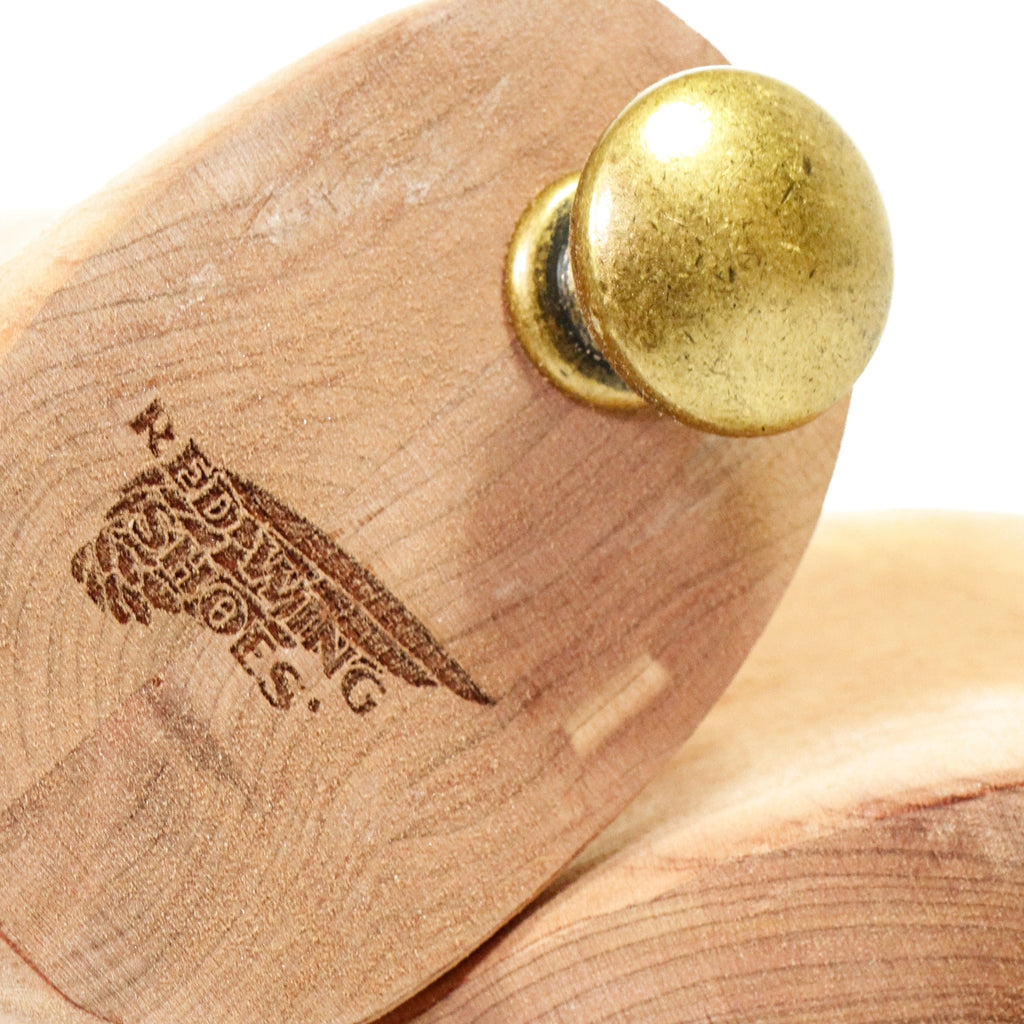Close-up of a cedar shoe tree heel with a brass knob and 'Red Wing Shoes' branding.