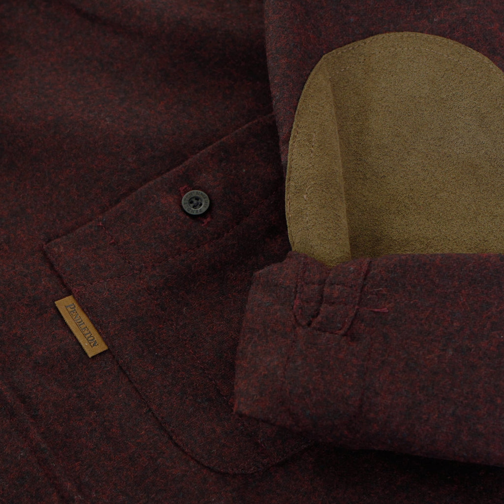 A close-up of the shirt's dark red fabric, highlighting a brown elbow patch and button details.
