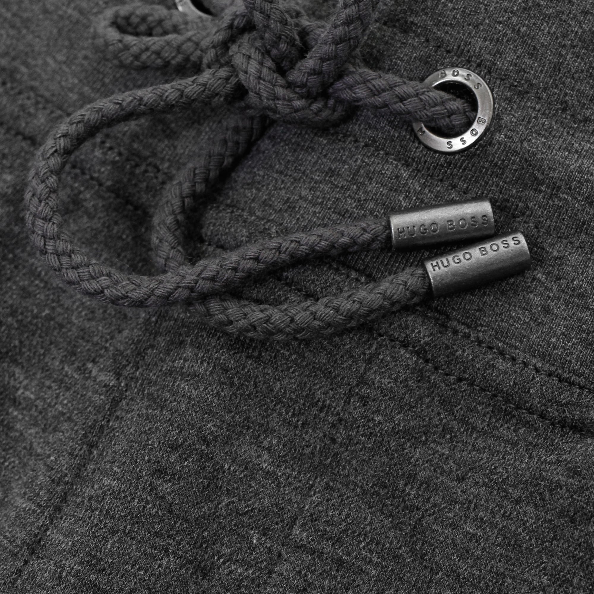 Close-up of the drawstring and metal-tipped cords on dark grey BOSS track trousers.