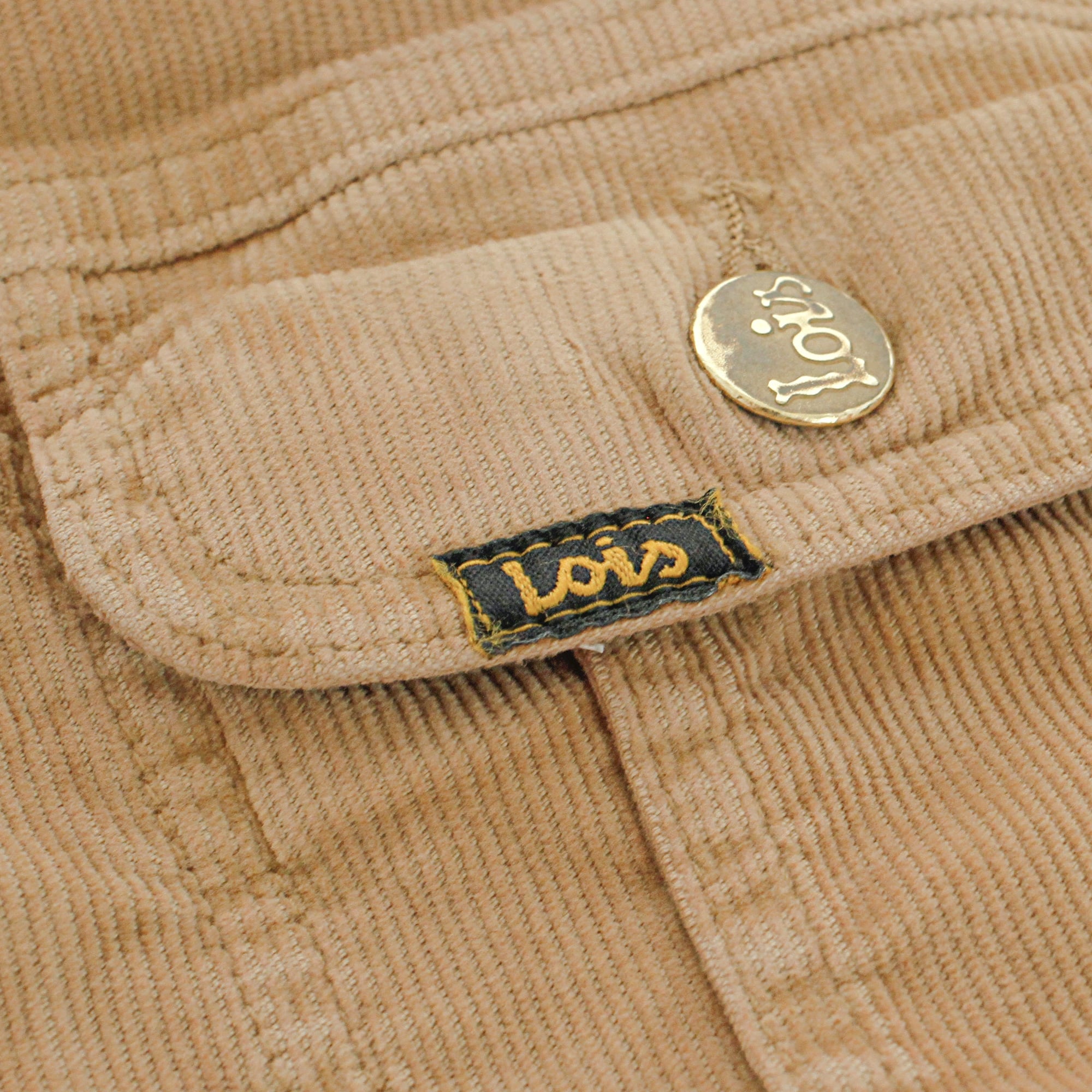Close-up of the Lois logo label and a button on the corduroy jacket.