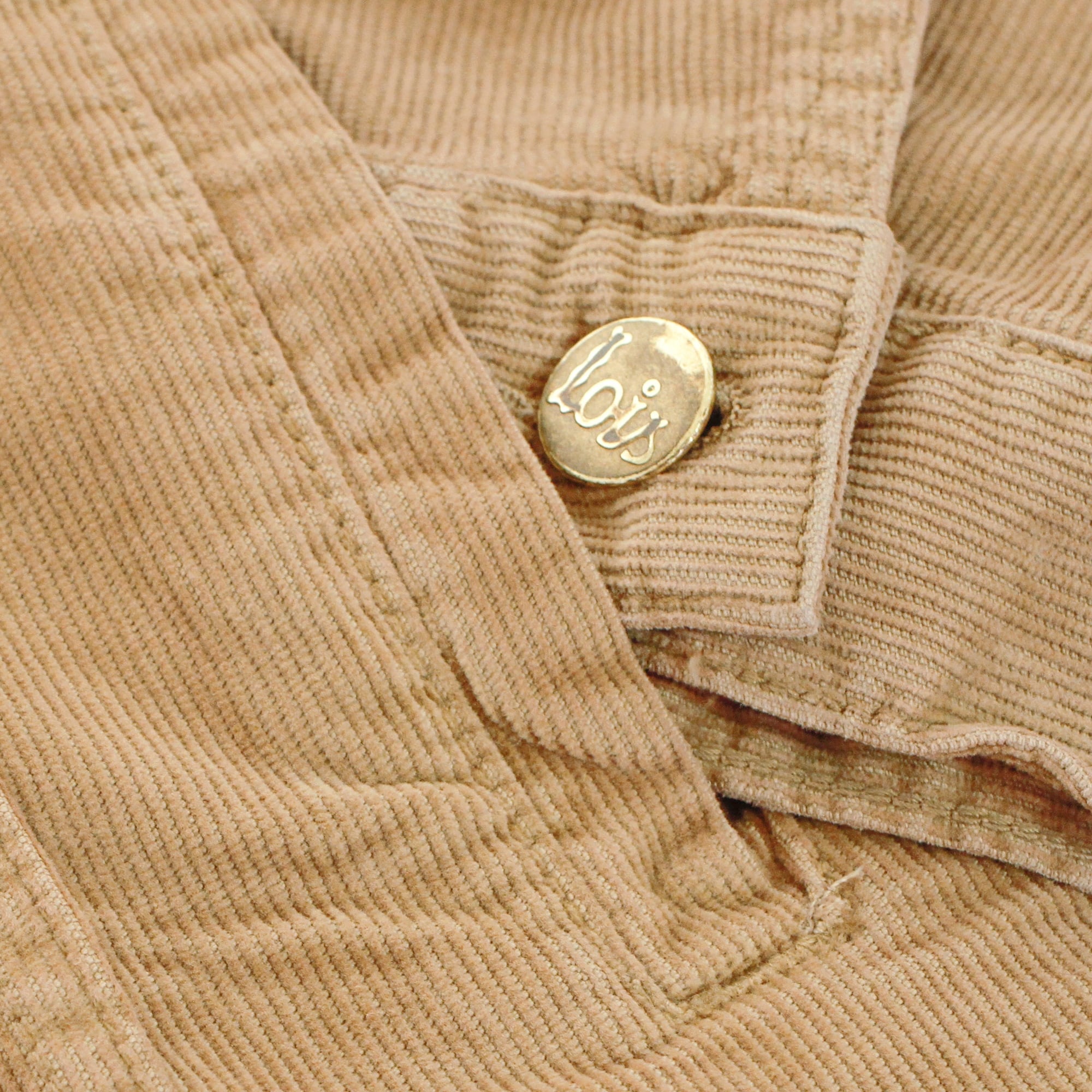 Close-up of a Lois-branded button on the cuff of the corduroy jacket.