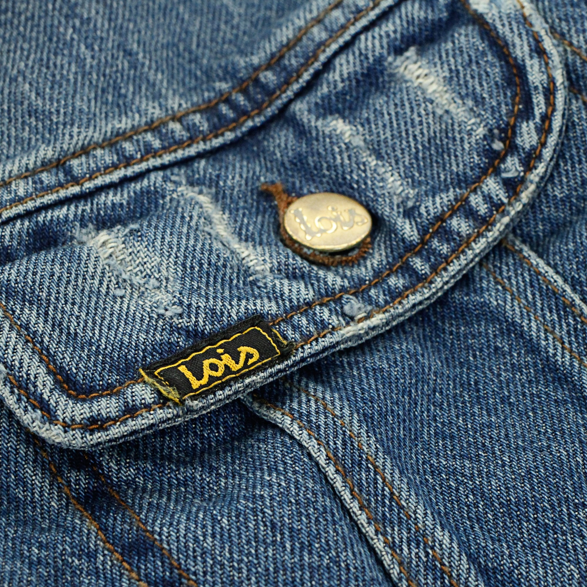 A close-up view of the breast pocket of the jacket, showing the 'Lois' branding.