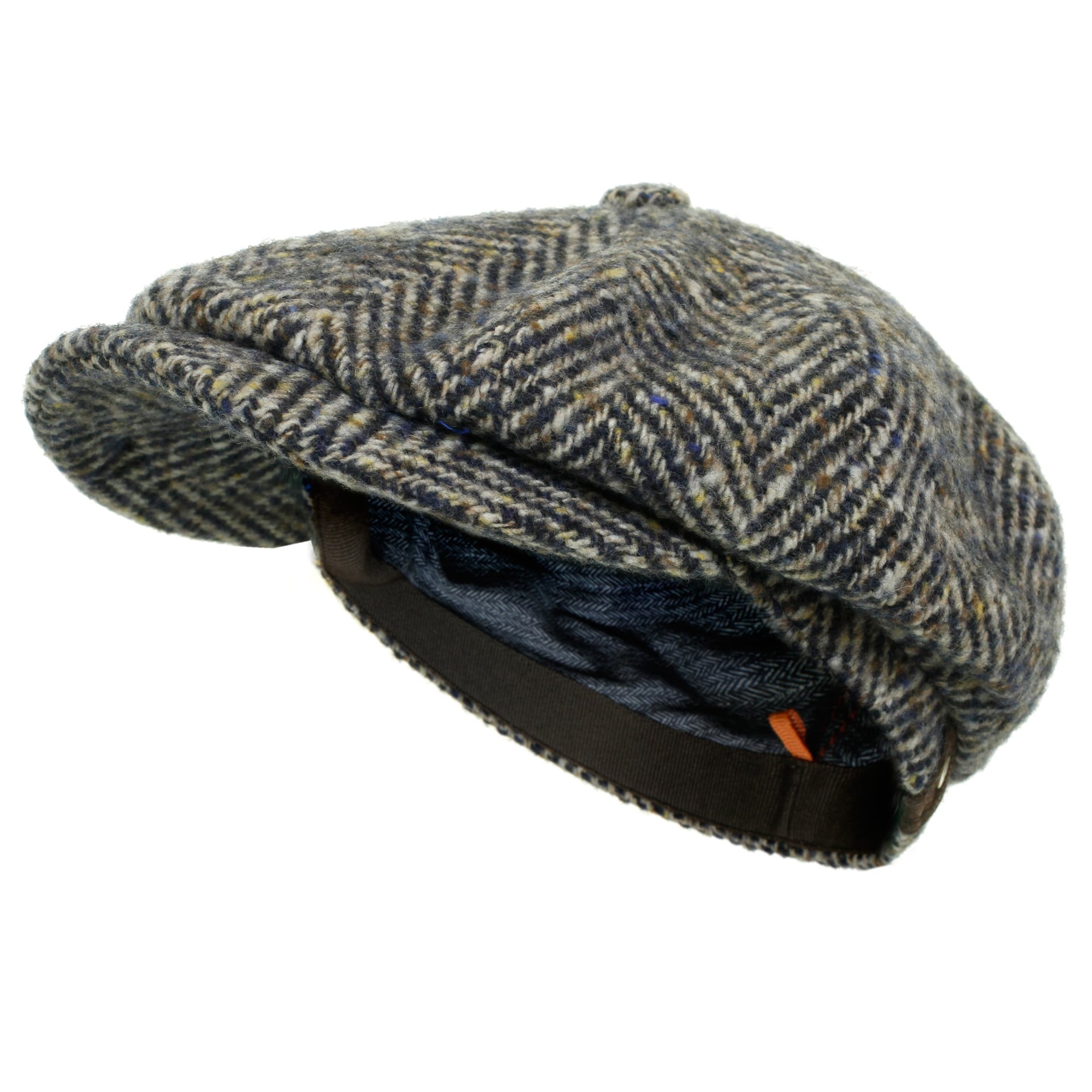 A grey and brown herringbone tweed flat cap, angled to show its brim and comfortable lining.