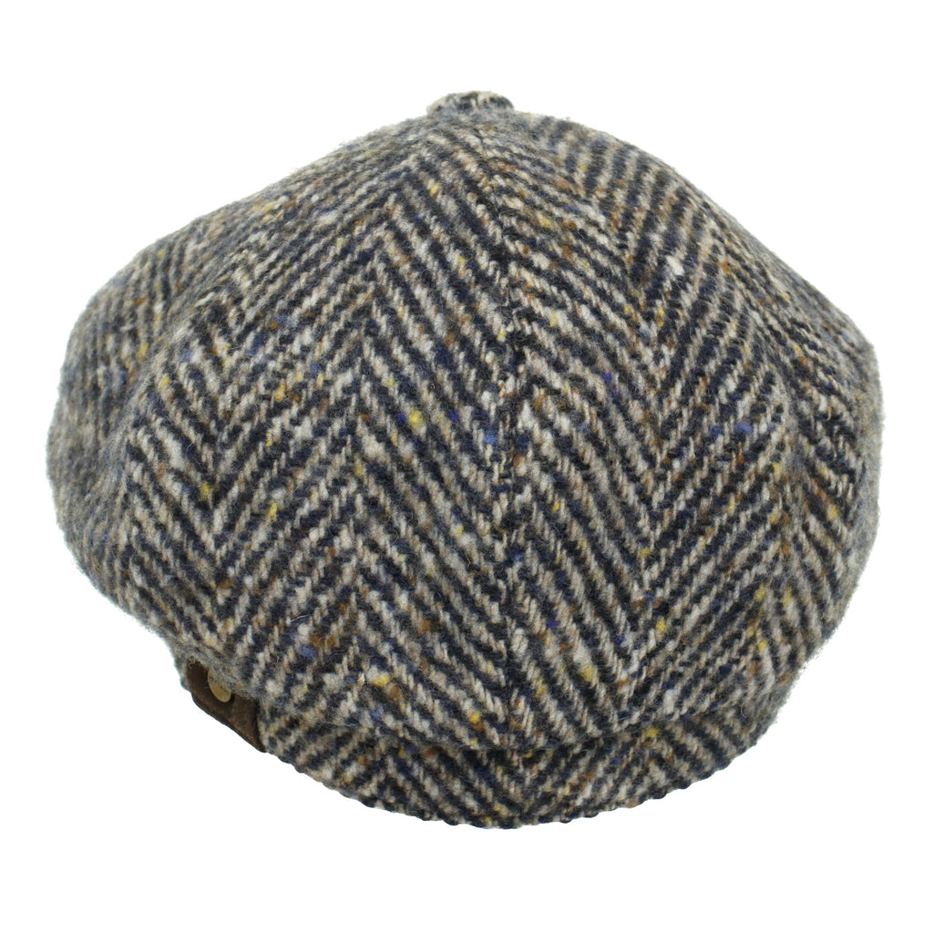 A grey and brown herringbone tweed flat cap, displayed from directly above.