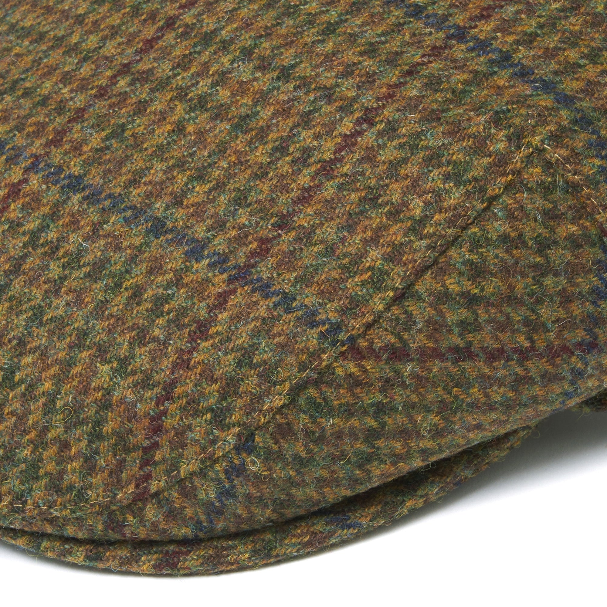 Close-up detail of the olive checked fabric and stitching on a flat cap.
