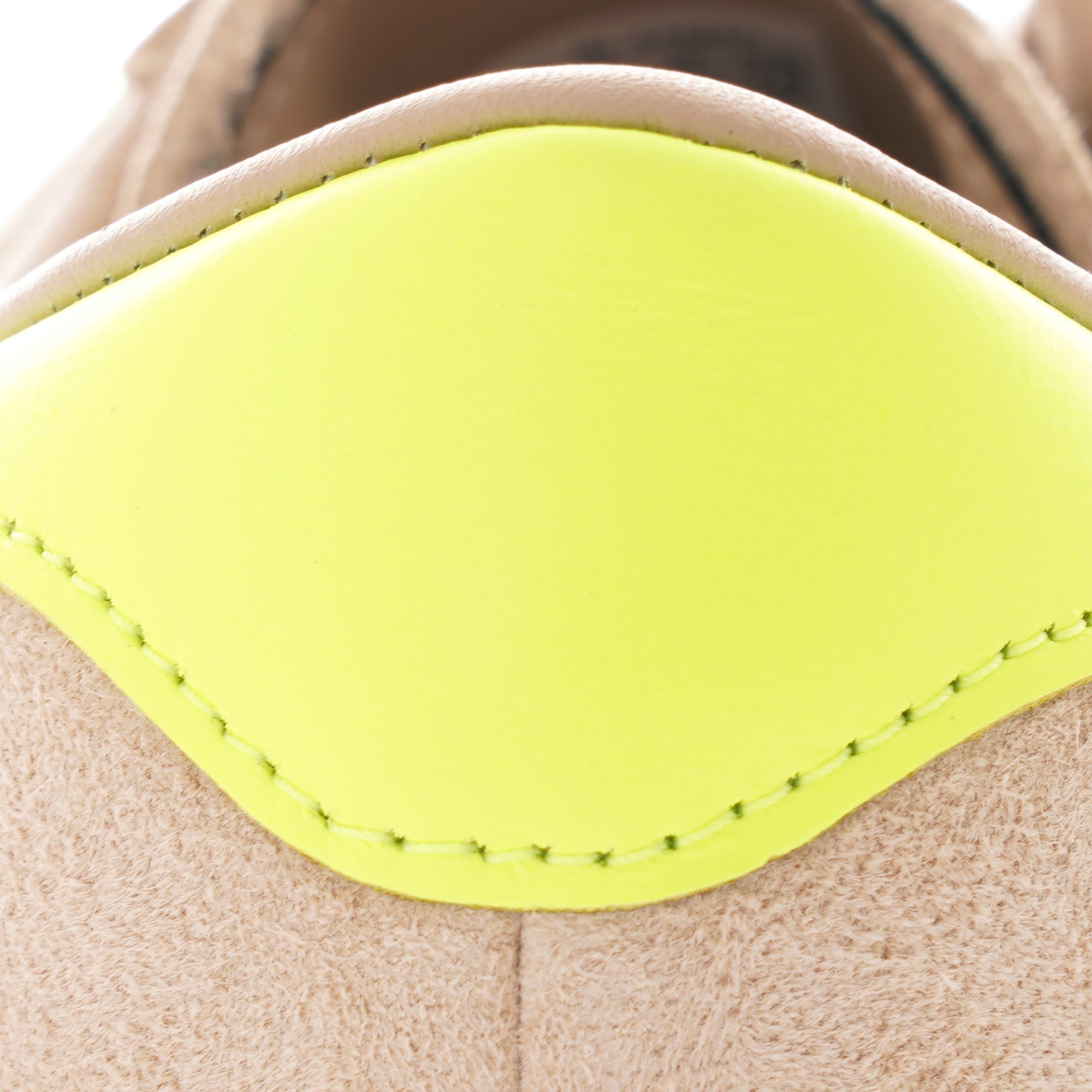 Close-up of the bright yellow heel tab on an Adidas Campus 80s trainer.
