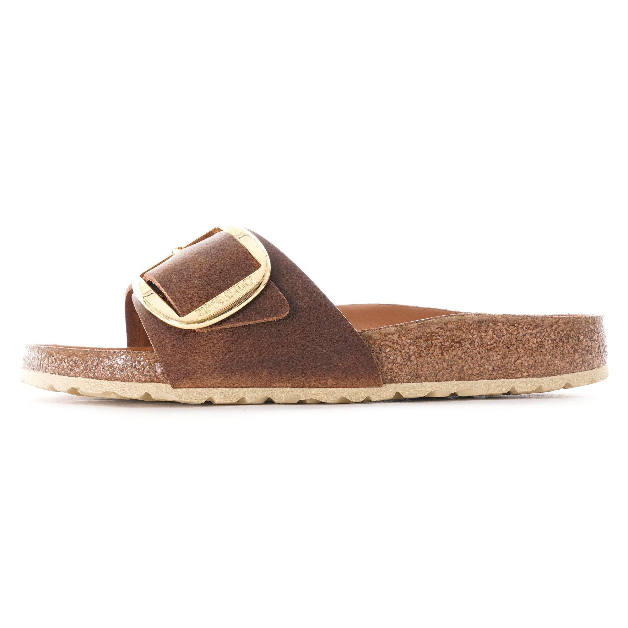 Brown sandal with a gold buckle on a white background, side view.