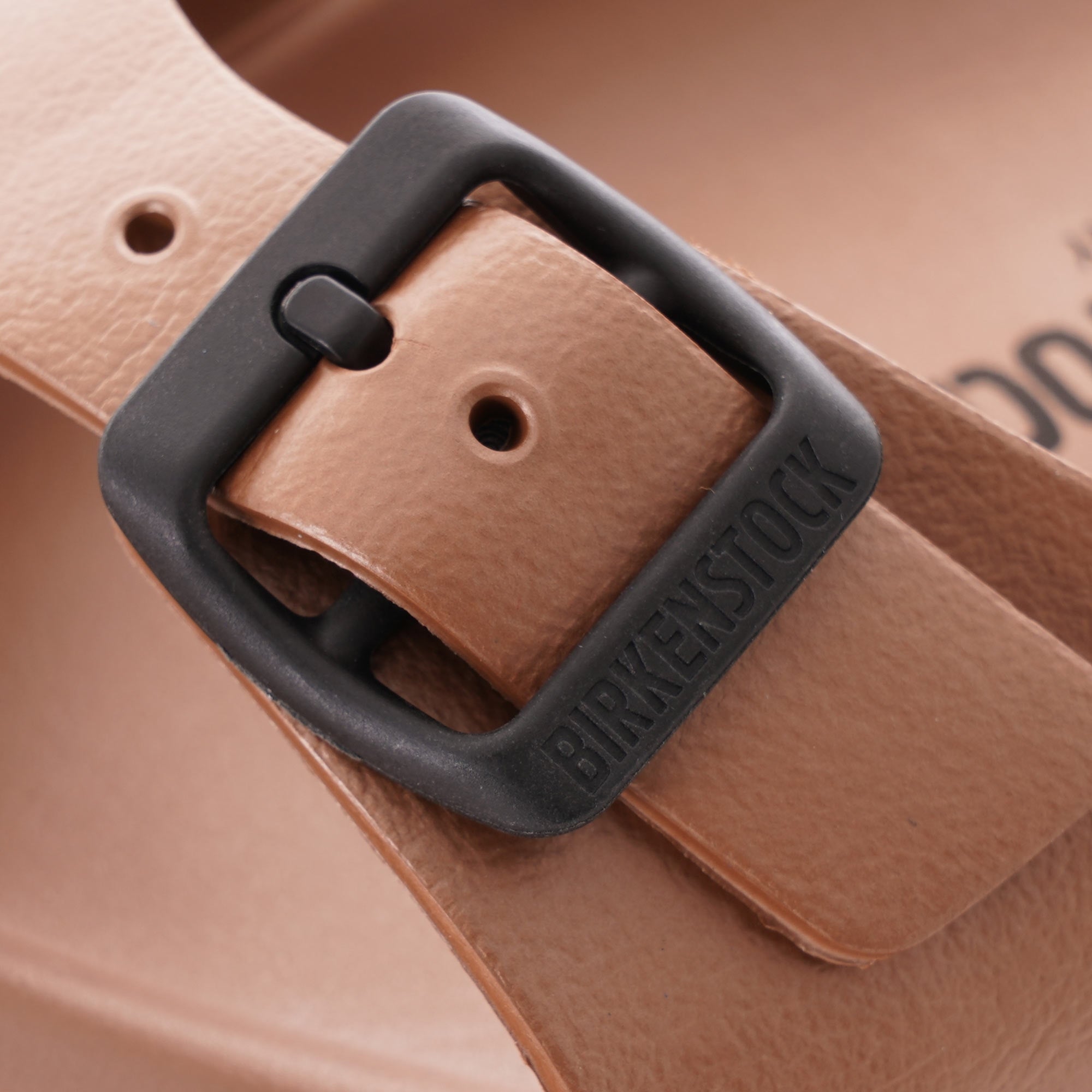 Close-up of the black buckle on a brown Birkenstock Honolulu EVA sandal.