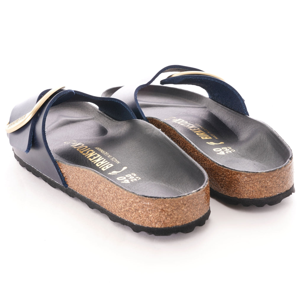 Rear view of a pair of navy blue slip-on sandals with a cork footbed.