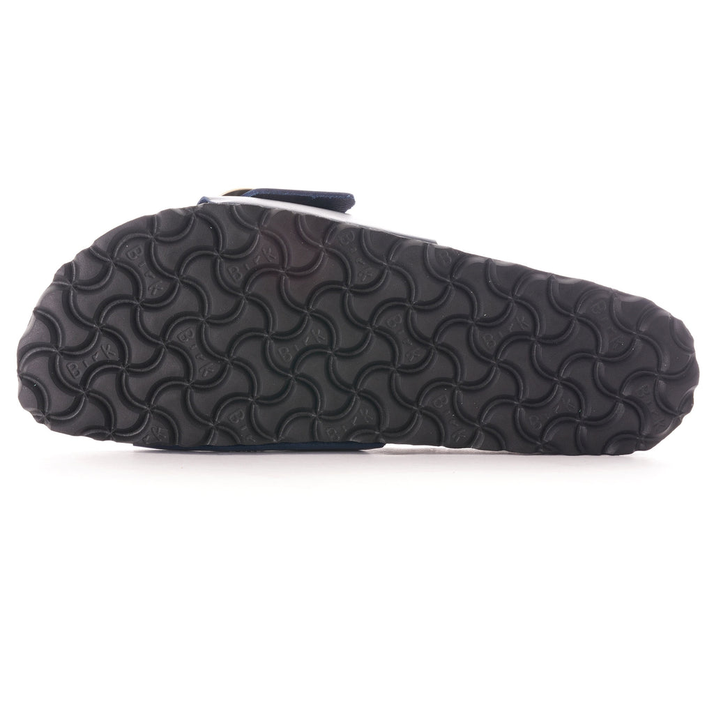 Bottom view of a navy blue sandal showing the patterned black sole.