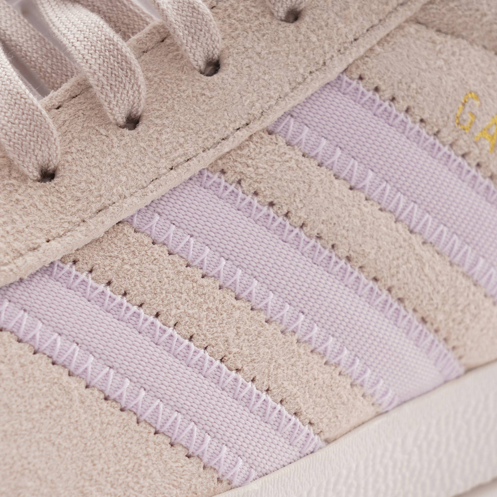 Close-up of the three light purple stripes on the side of an Adidas Gazelle trainer.