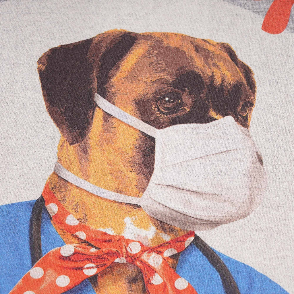 Close-up of a dog in a medical uniform with a mask and a red polka-dot scarf.