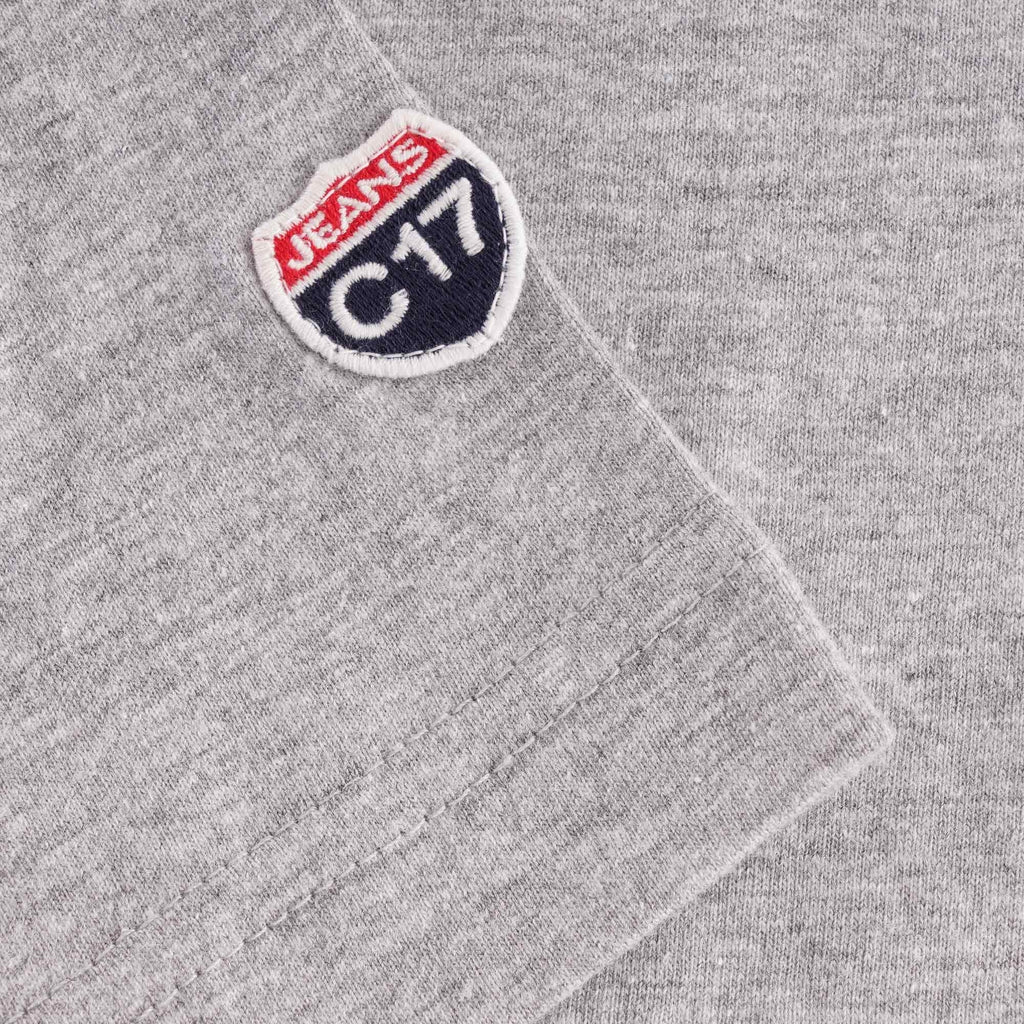 A close-up of the 'C17 Jeans' patch on the sleeve of a grey T-shirt.