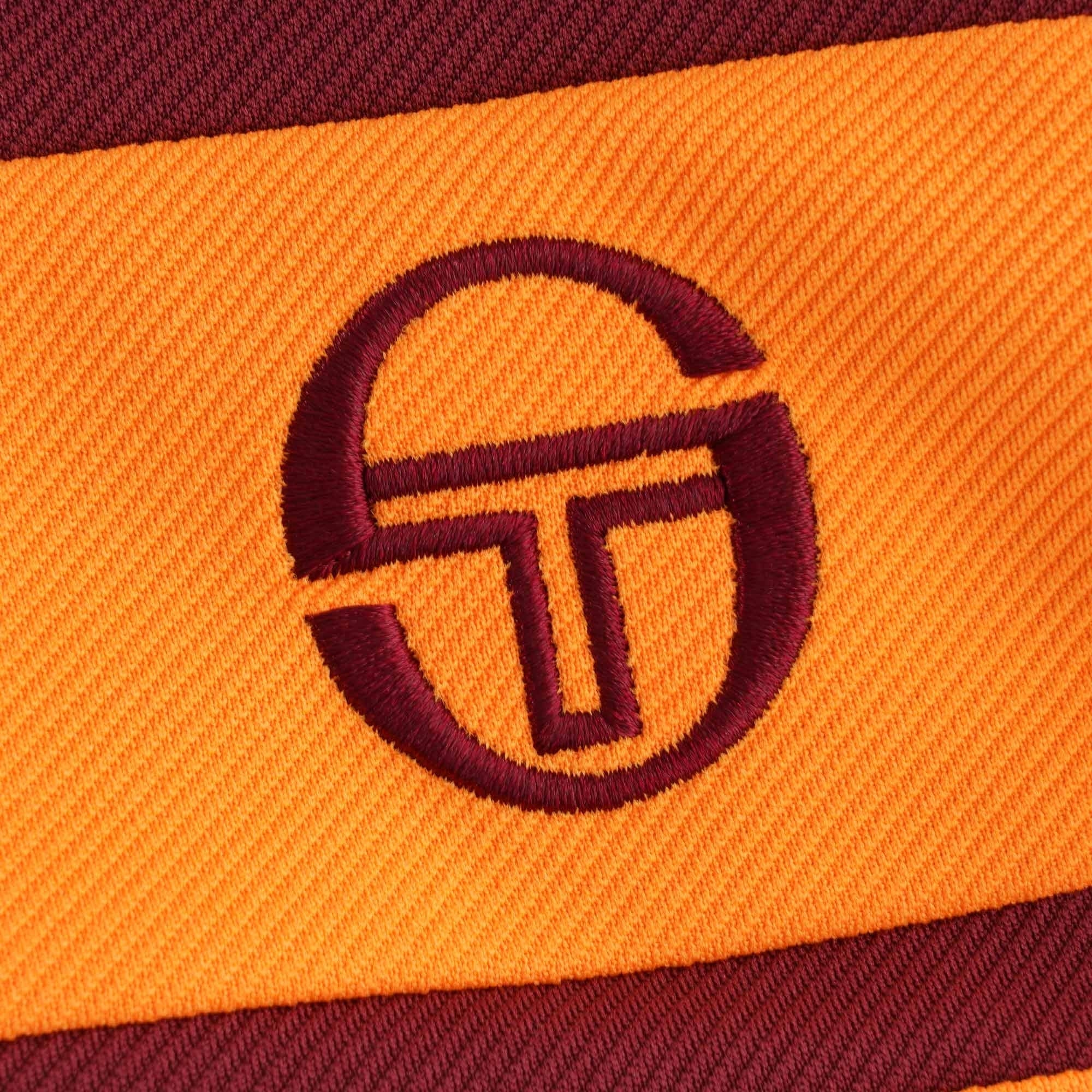 A close-up of the embroidered Sergio Tacchini logo on the track top.