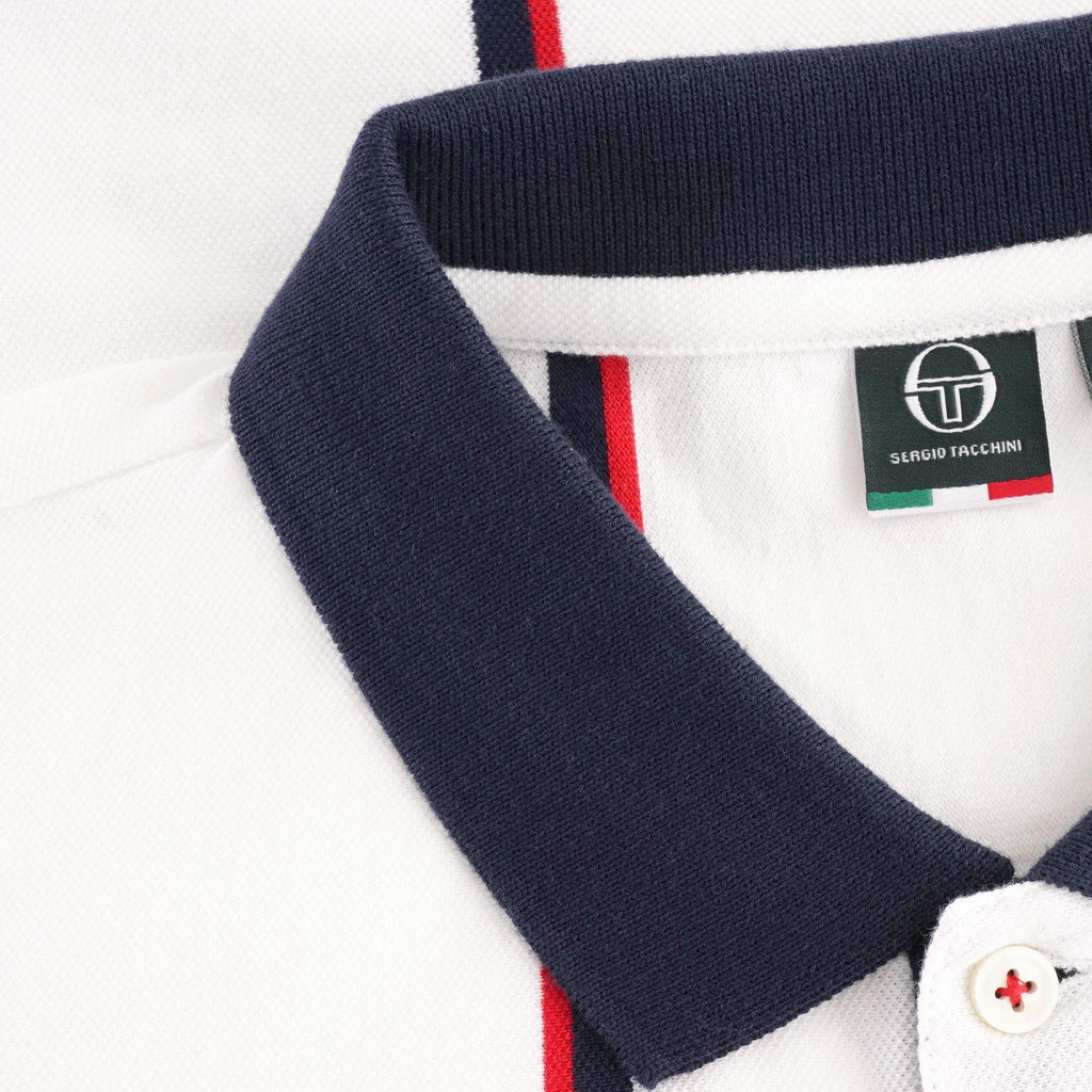 Close-up of the white polo shirt's navy collar and a visible brand tag.