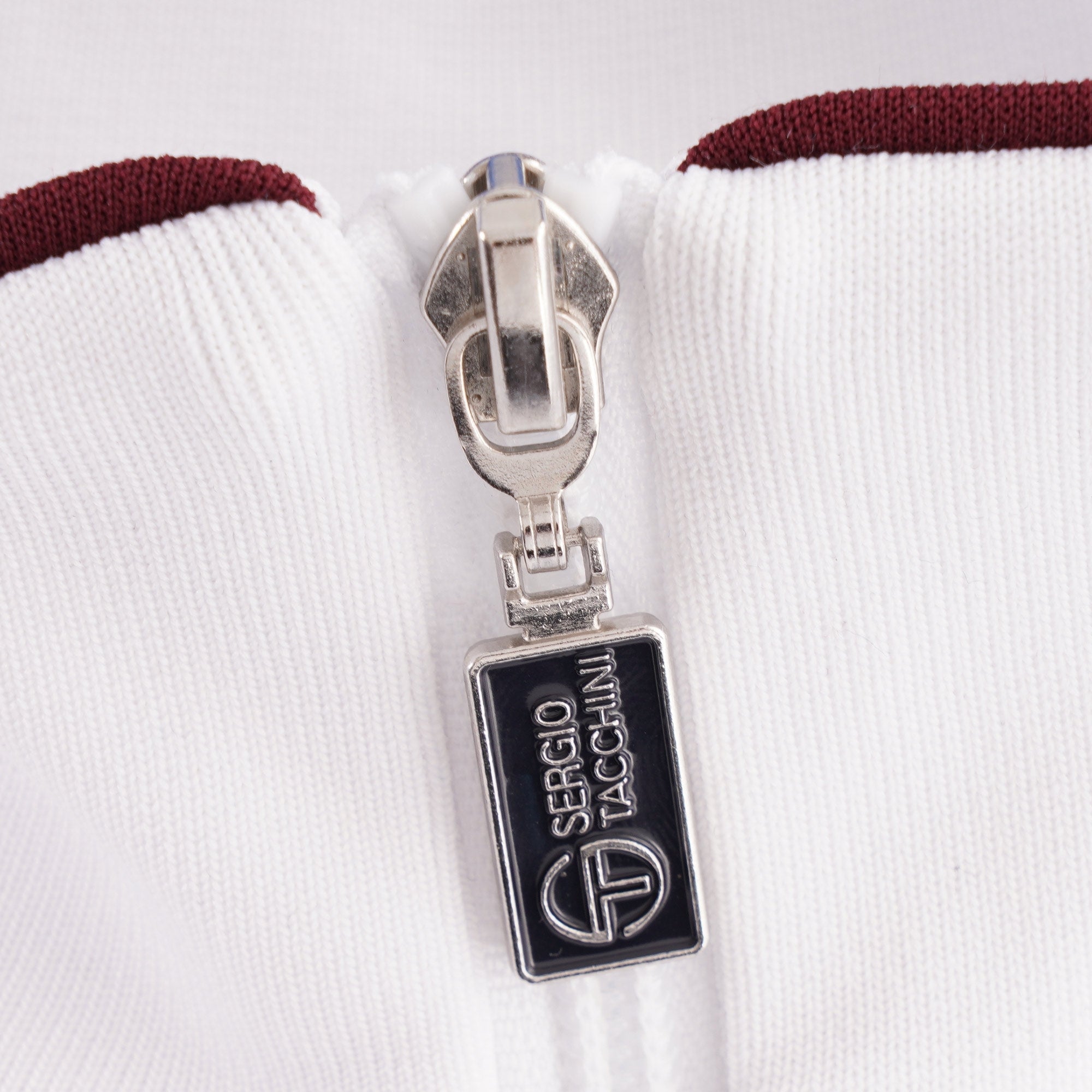 Detailed view of the Sergio Tacchini branded zipper pull.