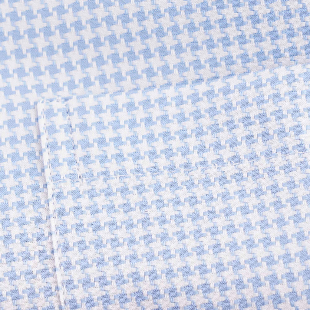 Detailed view of the light blue and white houndstooth fabric pattern on the shirt.