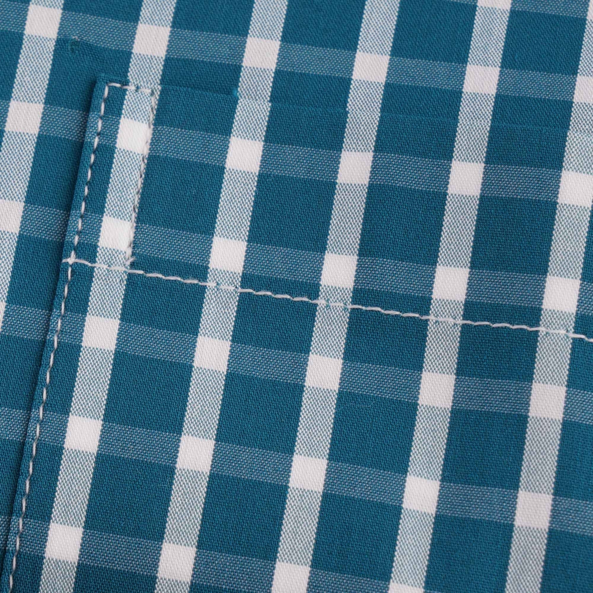 Close-up of the shirt pocket, highlighting the checked fabric and stitching.