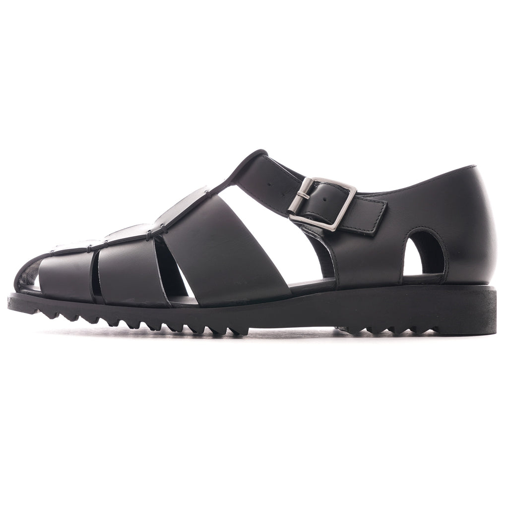 A single black leather fisherman sandal with a side buckle closure and ridged sole.