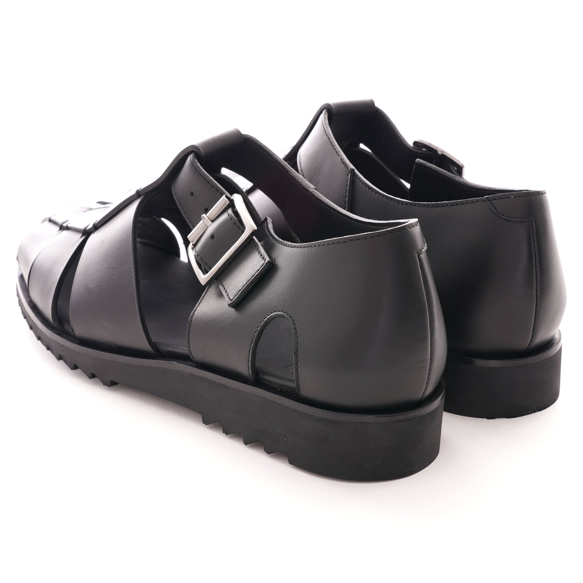 A rear view of two black leather fisherman sandals, showcasing the heel and buckle.