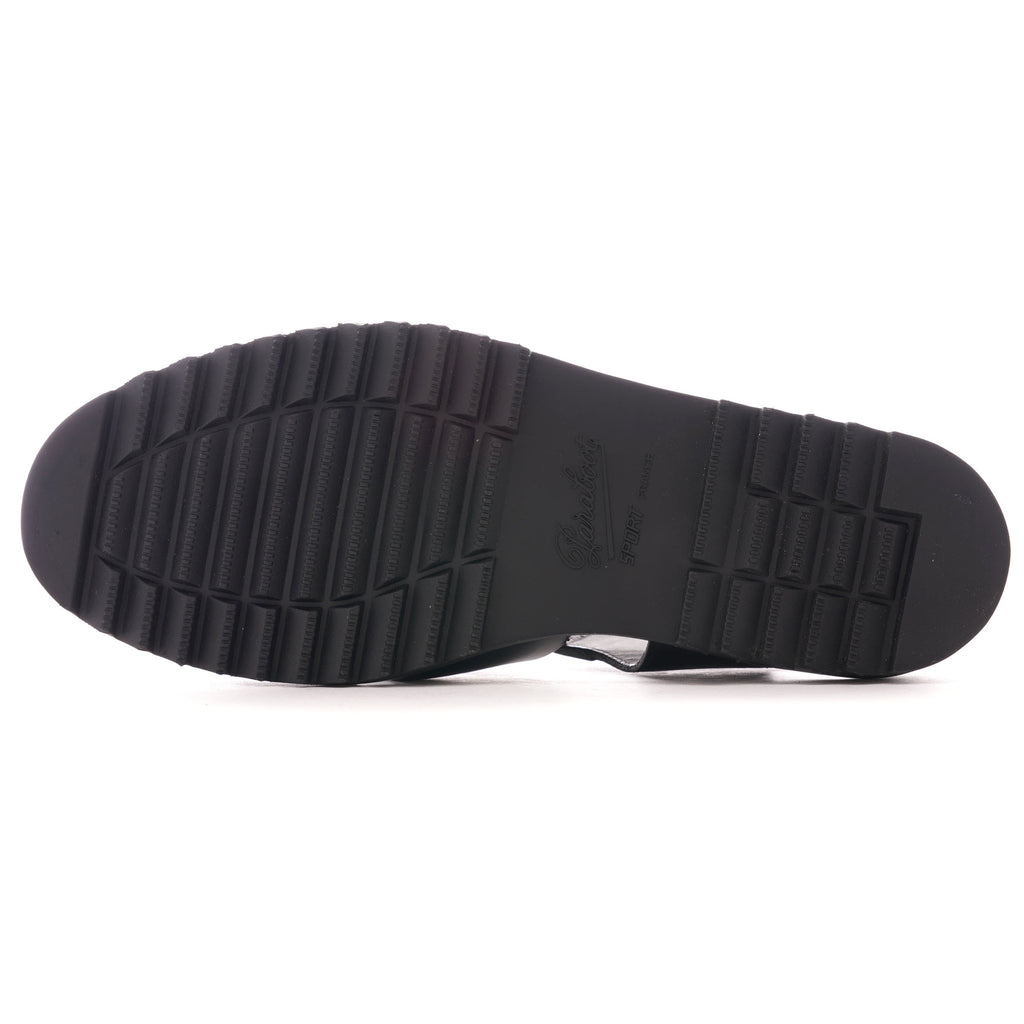 The textured, ridged black sole of a fisherman sandal.
