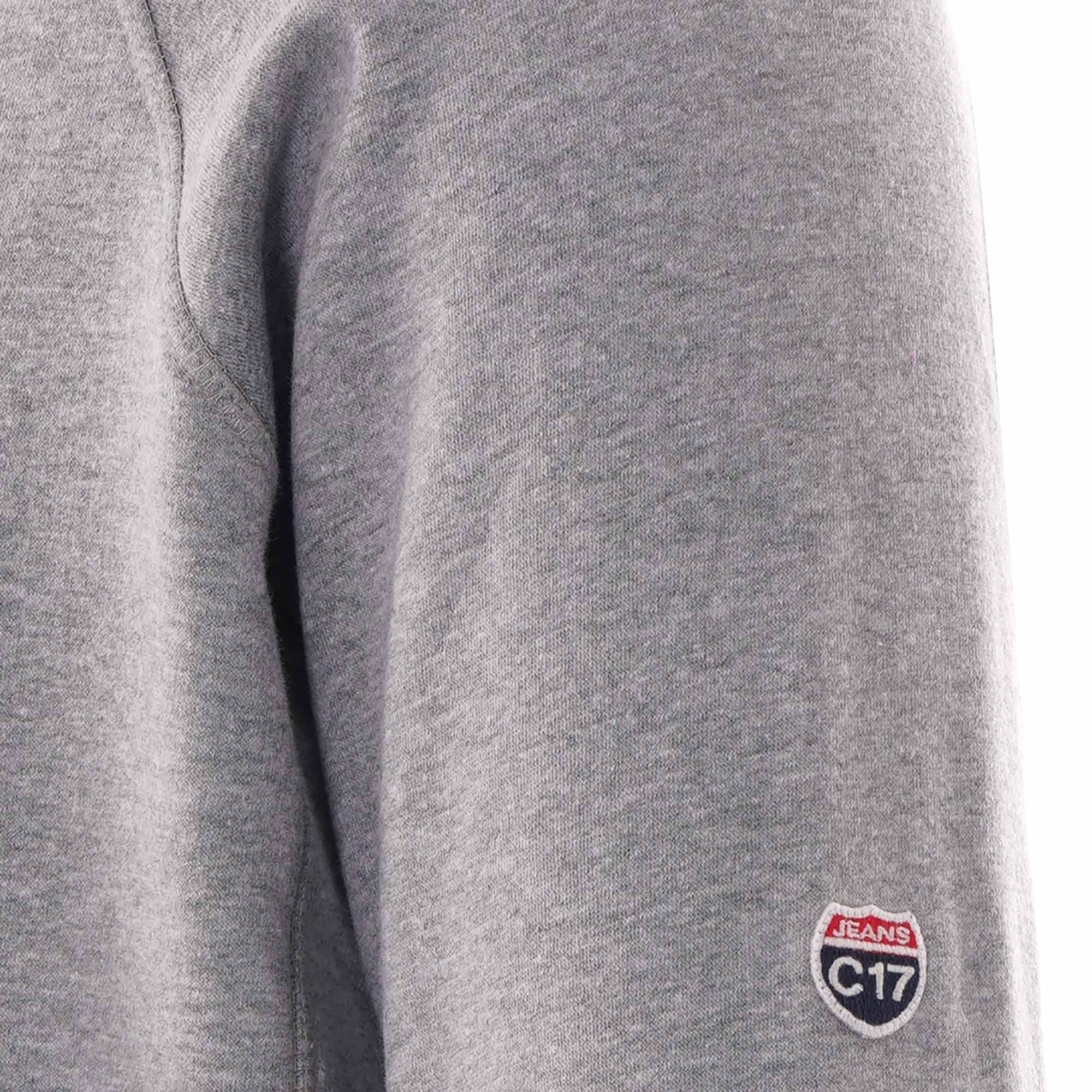 A close-up of the left sleeve of the grey hoodie, showing a C17 Jeans patch.