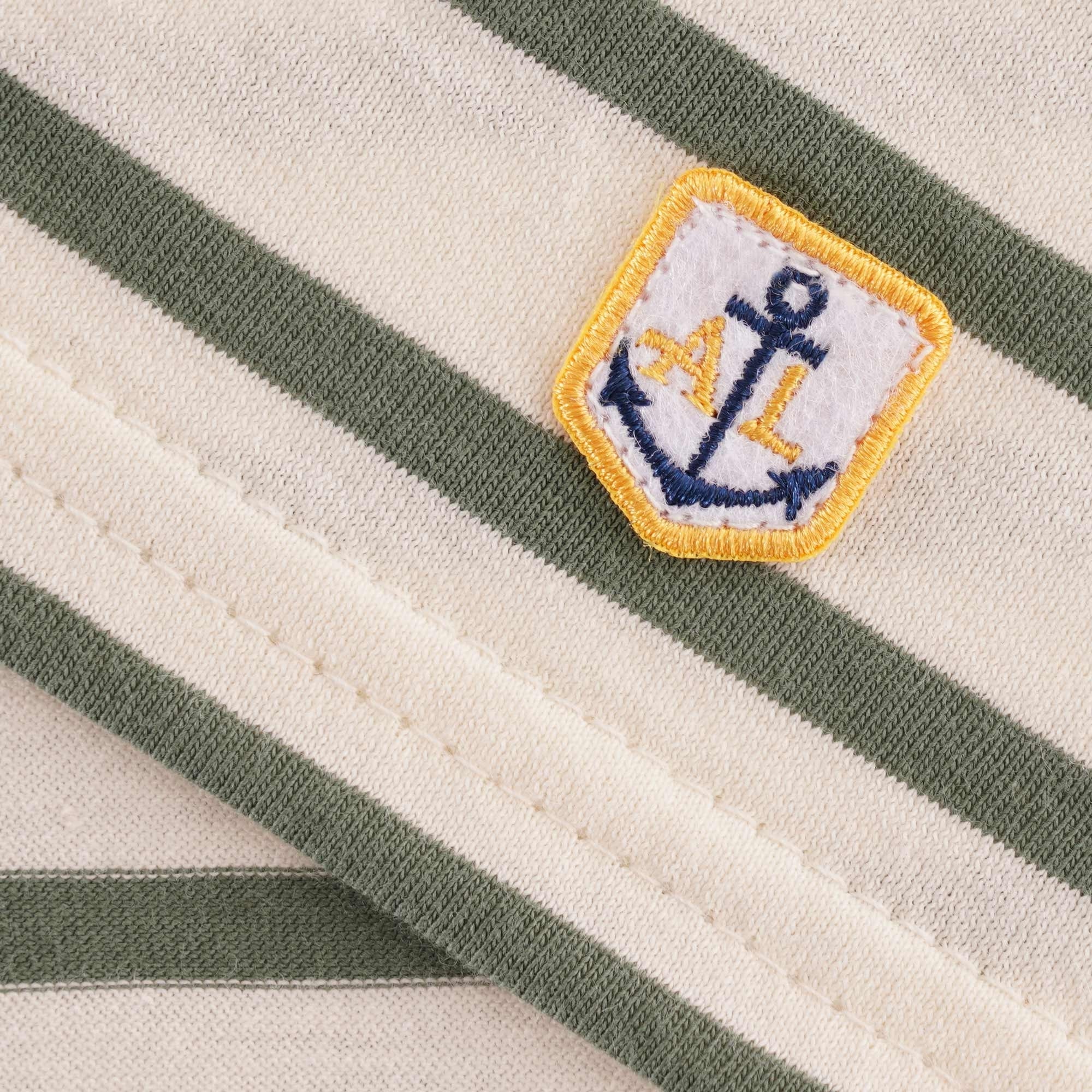 A small embroidered anchor logo on the t-shirt.