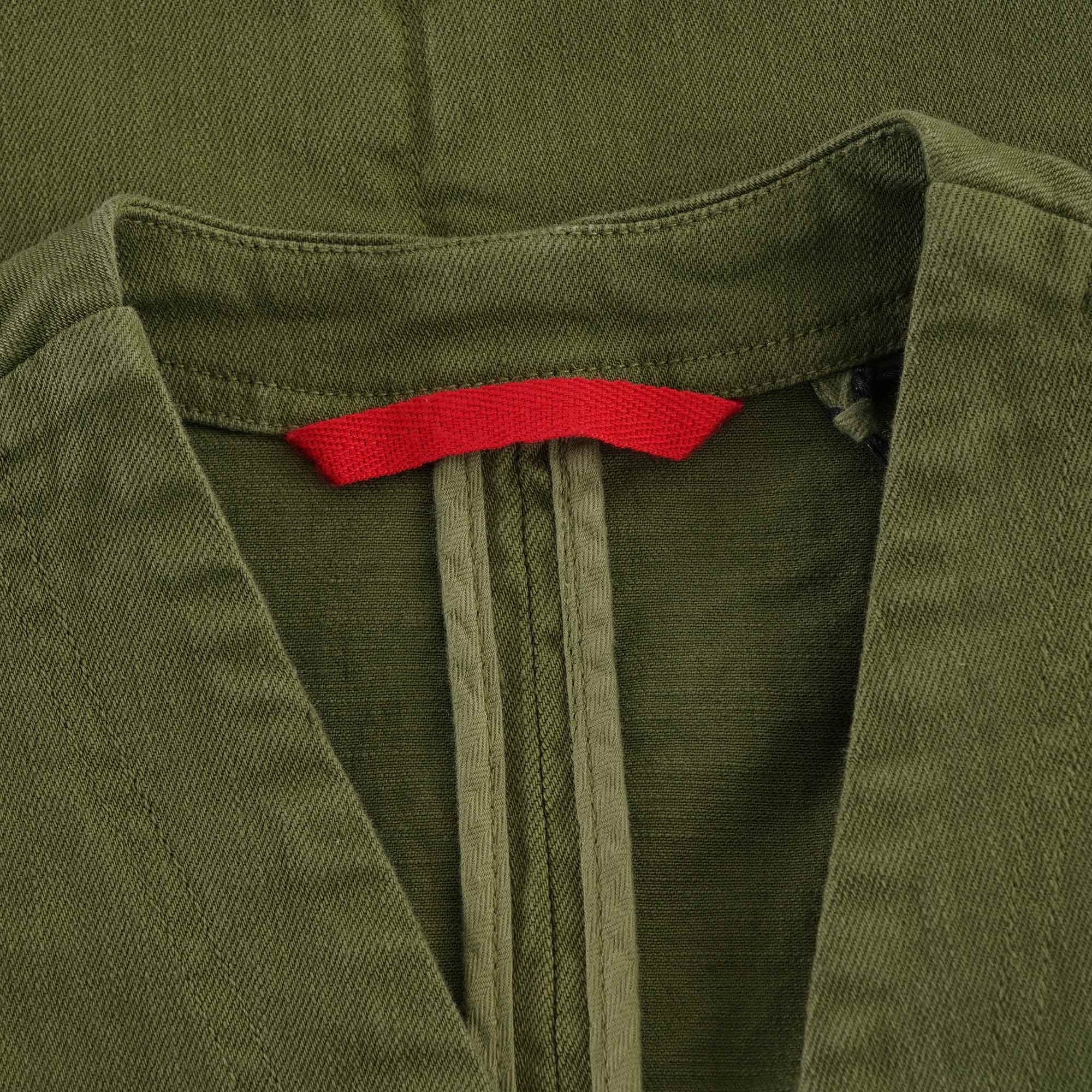 Close-up of the collar and red tag on an olive green waistcoat.