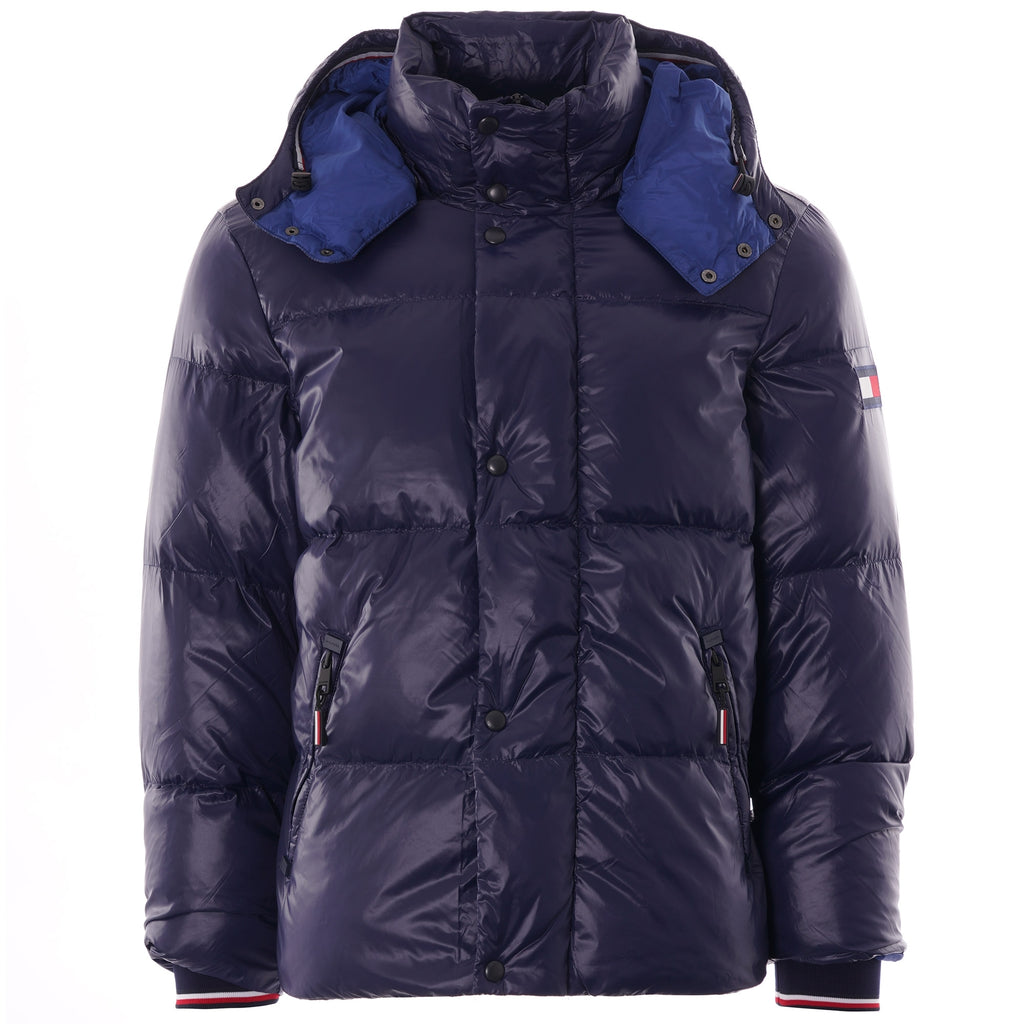 A navy blue puffer jacket with a hood, blue lining, and a small flag logo on the arm.