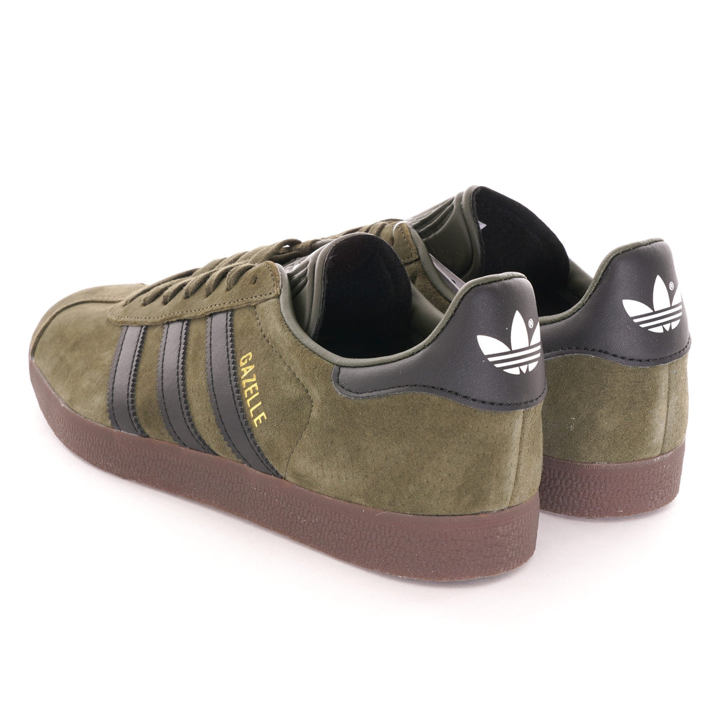 The rear view of a pair of olive green suede Adidas Gazelle trainers with black heel tabs. 