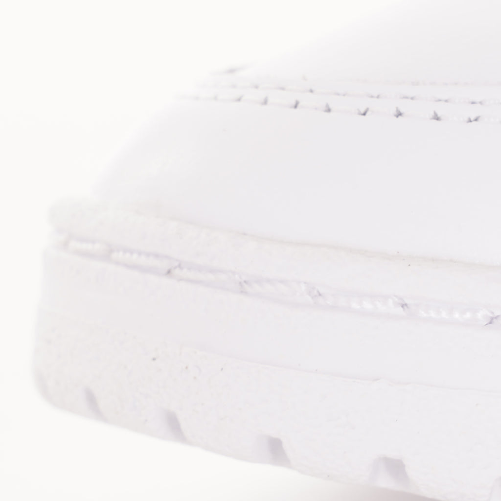 A close-up of the textured toe-cap of a white Adidas trainer with blue and red stripes.