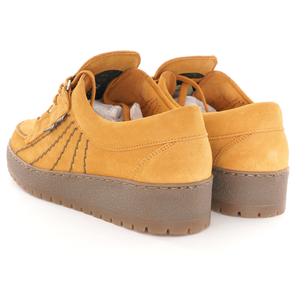 A pair of mustard yellow Mephisto 'Rainbow' shoes viewed from the back, on a white background.
