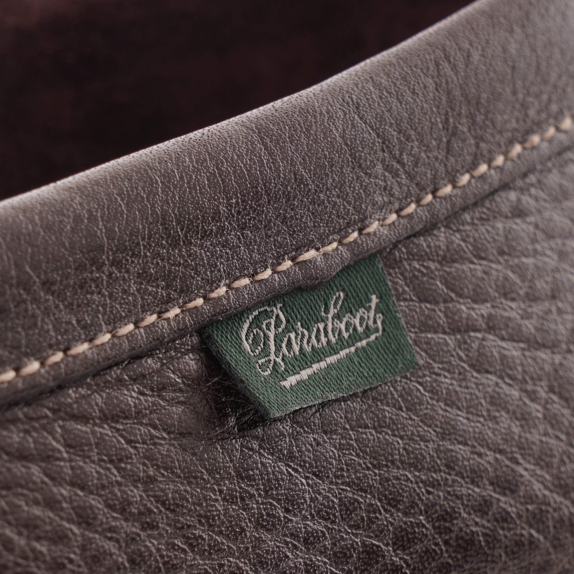 Close-up of the green Paraboot brand tag on the brown leather loafer.