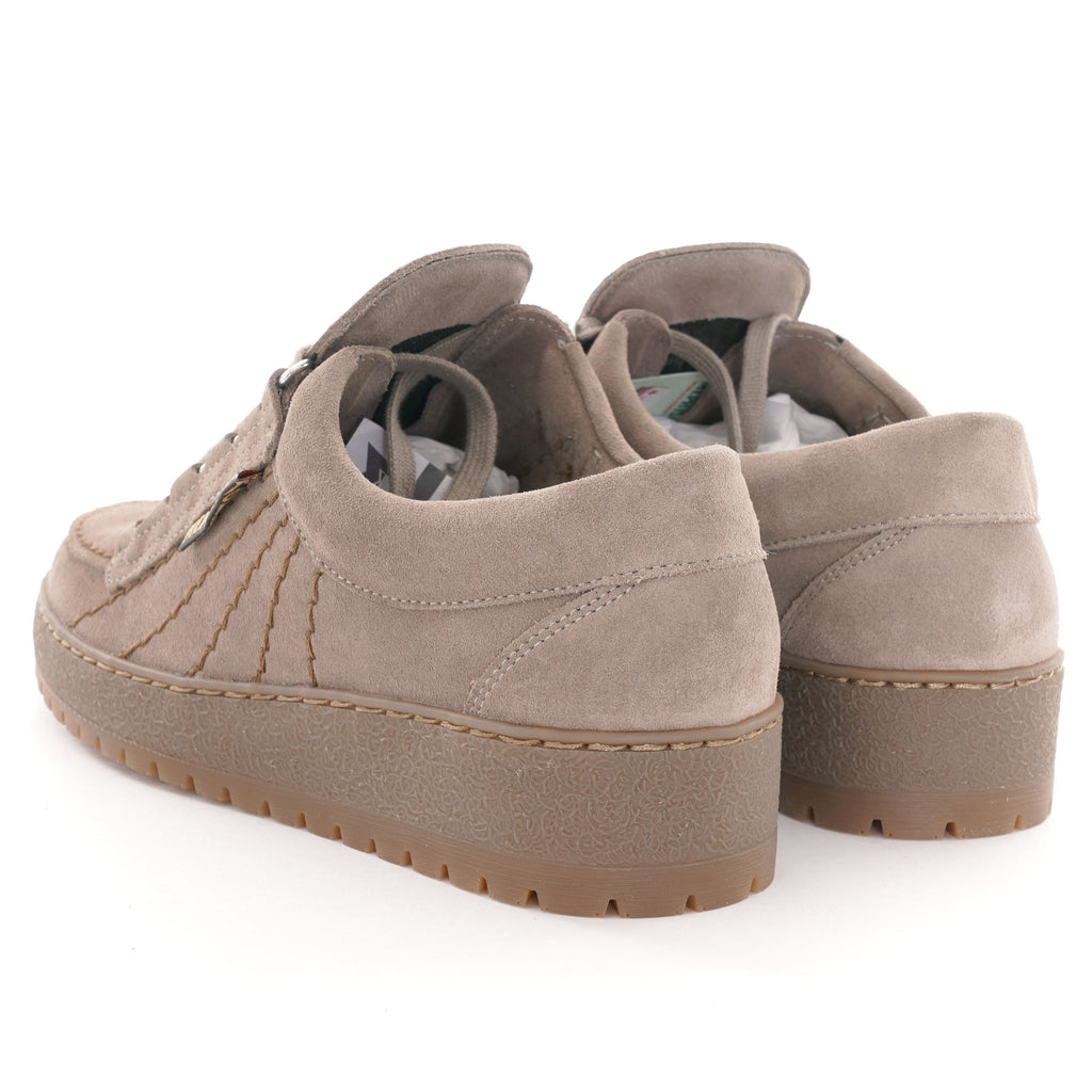 A pair of beige suede shoes with thick soles, viewed from the rear.