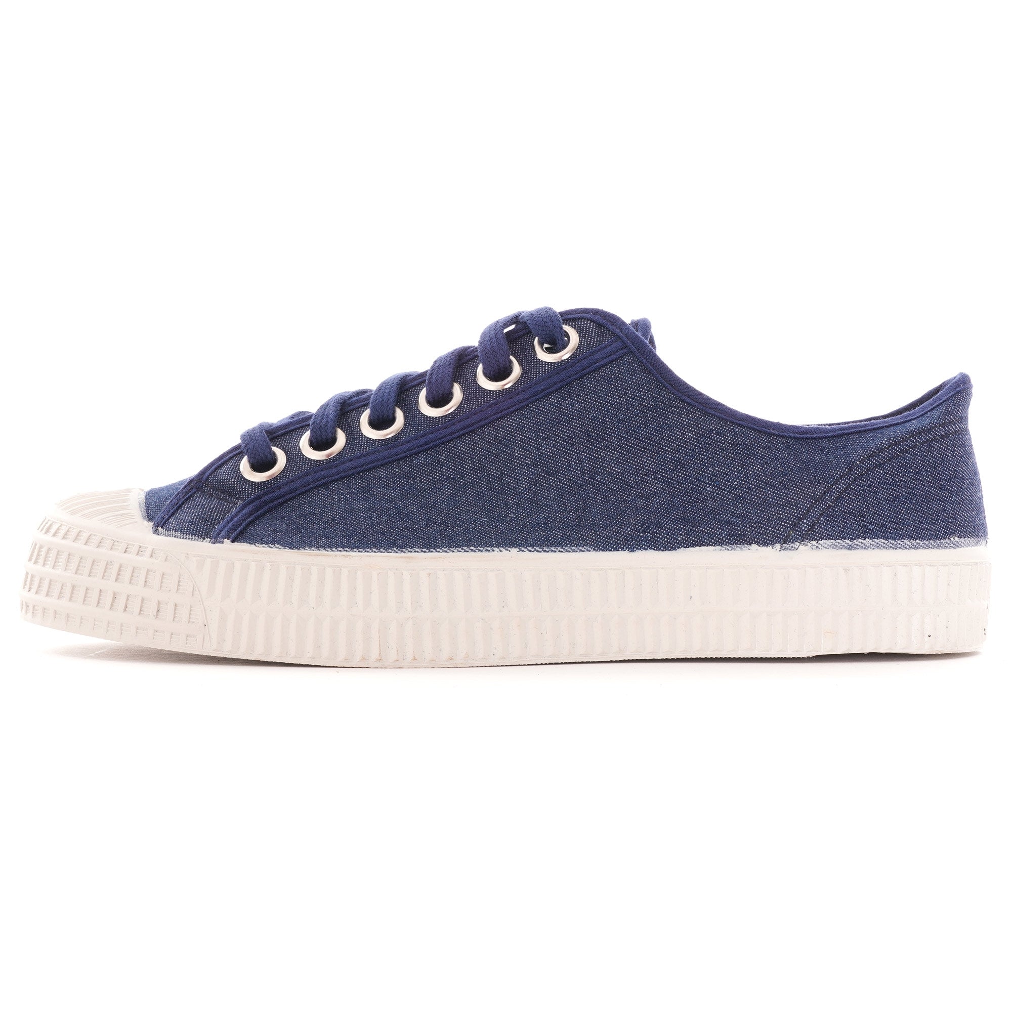 Side profile of a single navy blue canvas shoe with white laces and sole.
