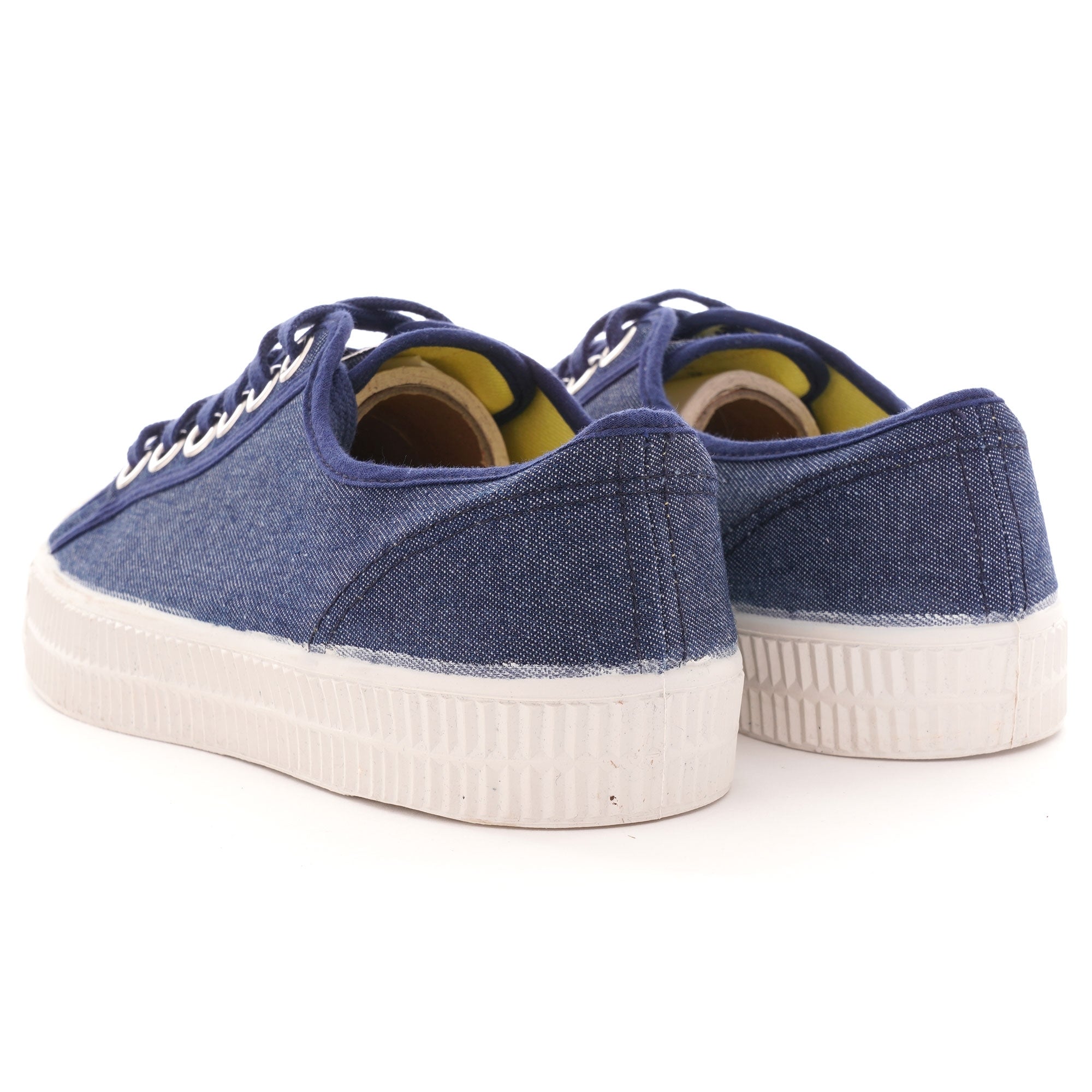 Rear view of the pair of shoes, highlighting the navy blue canvas and white soles.