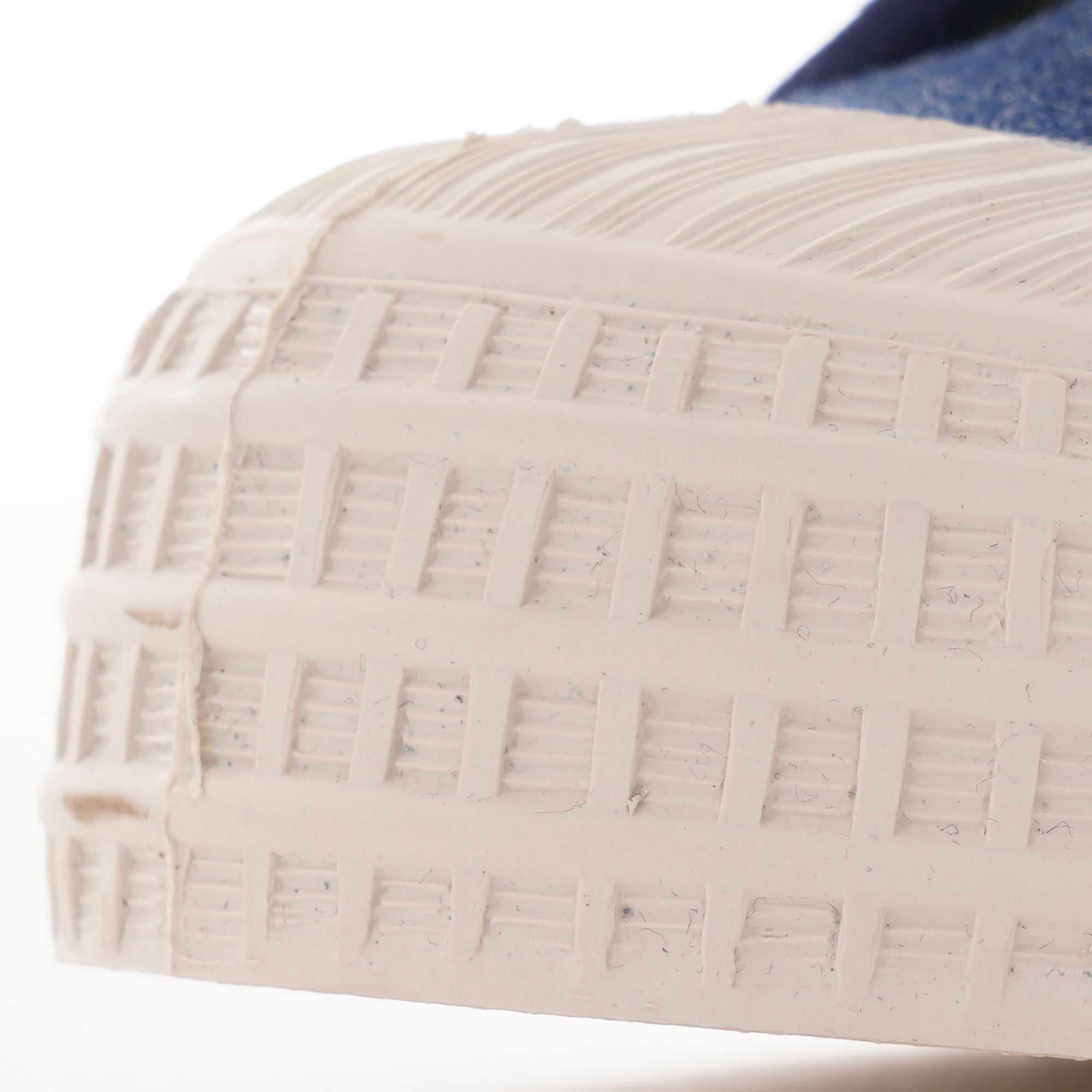 Close-up of the textured white rubber toe cap and sole of the shoe.