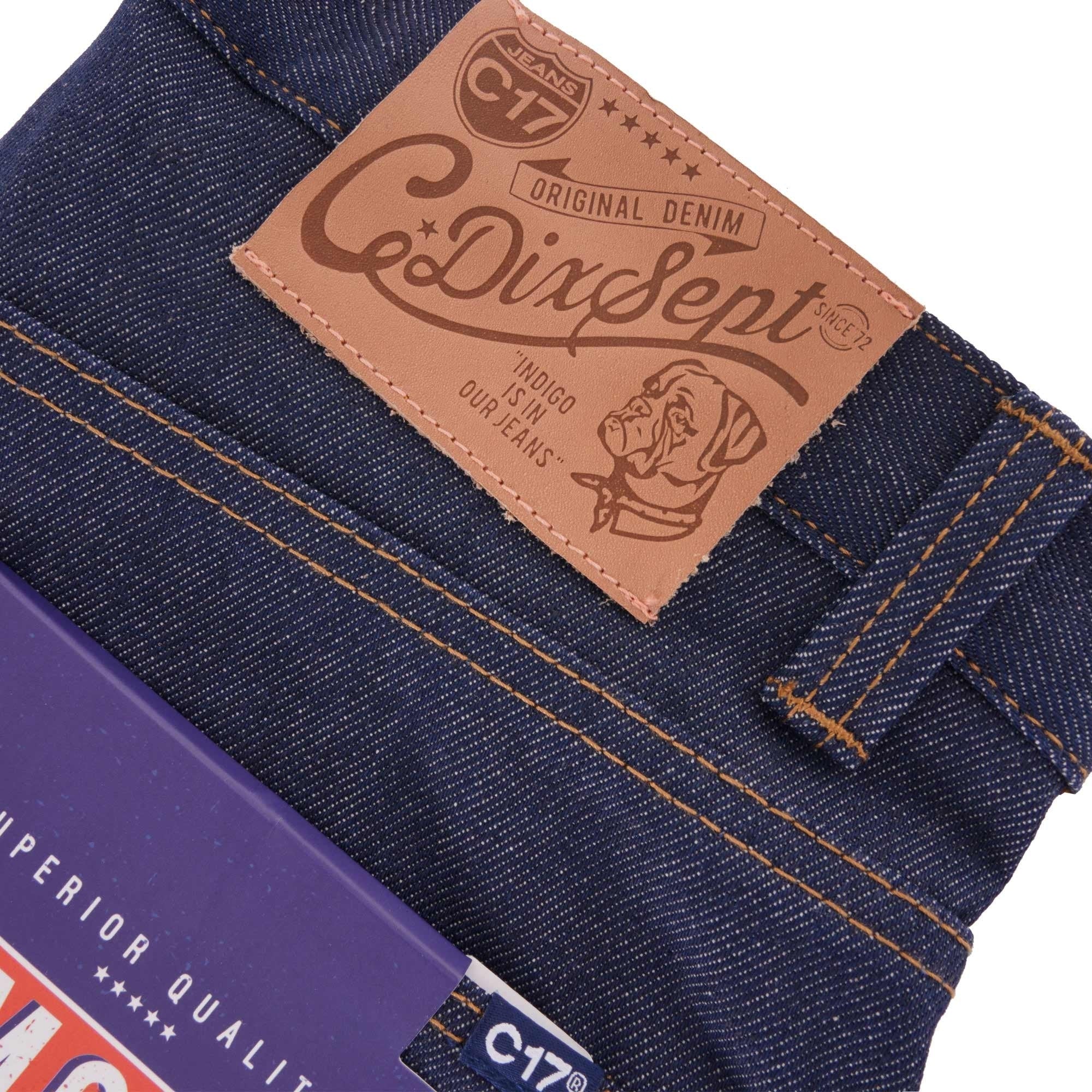 Close-up of the C17 leather patch on the waistband of indigo denim jeans.