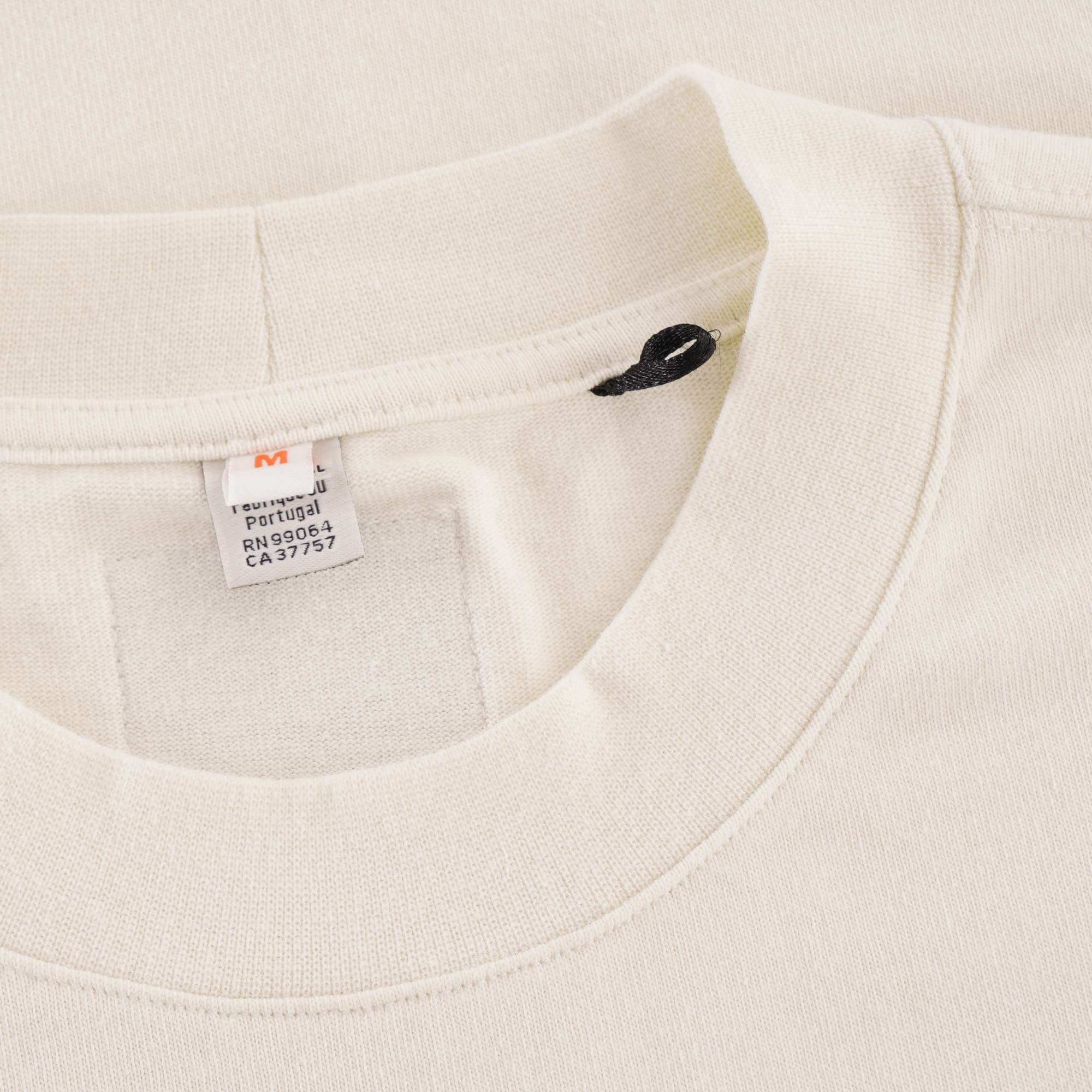A close-up of the t-shirt's collar, showing a black tag and a white care label.