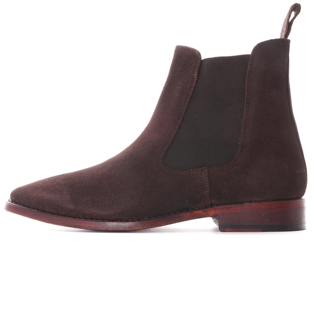 Side profile of a single brown suede Chelsea boot.