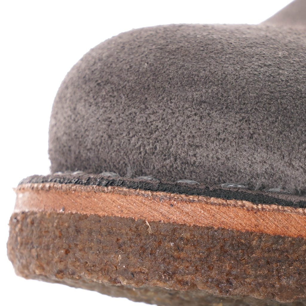 Close-up of the grey suede upper and brown sole of a desert boot.