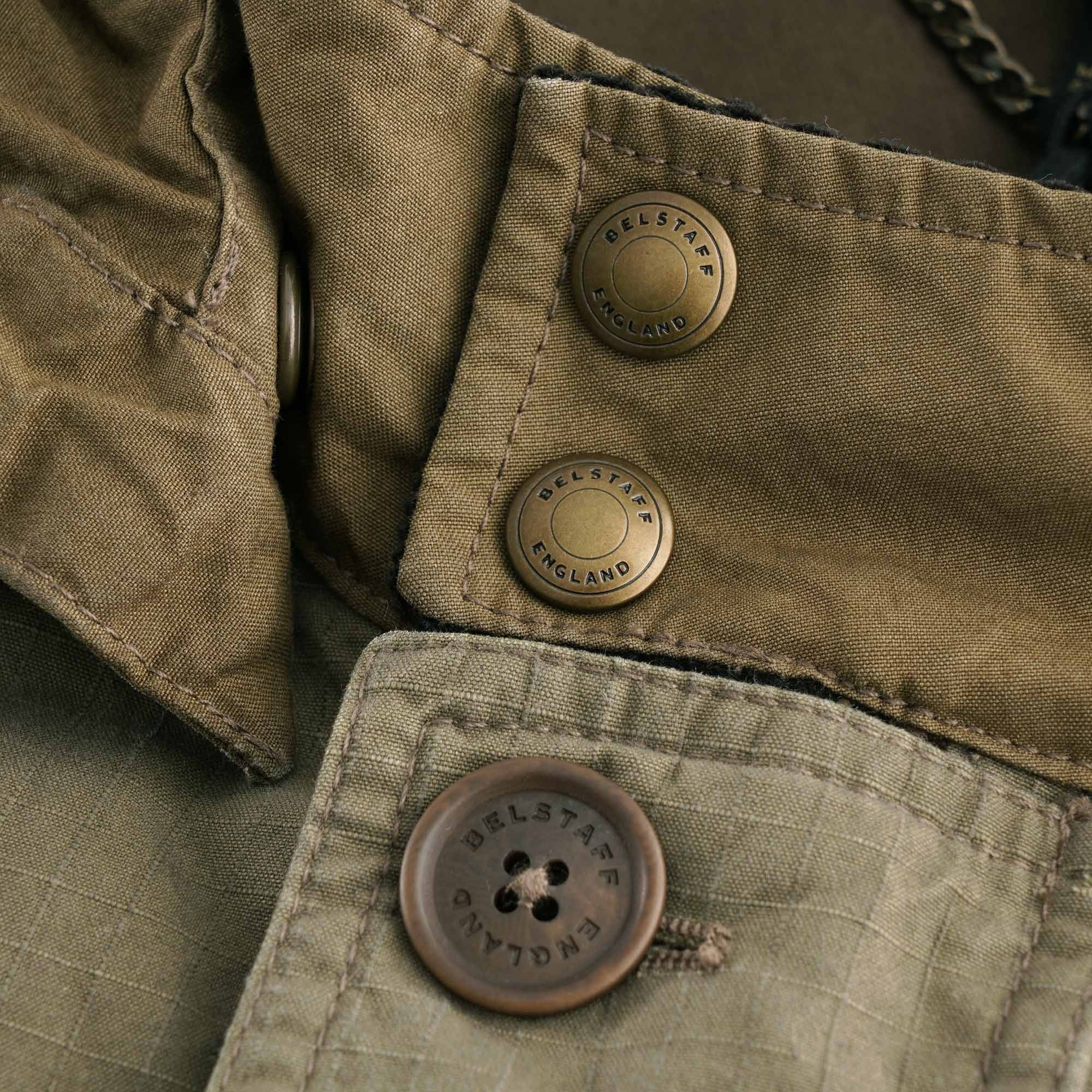 Detail of the jacket's press studs and button, both branded 'BELSTAFF ENGLAND'.