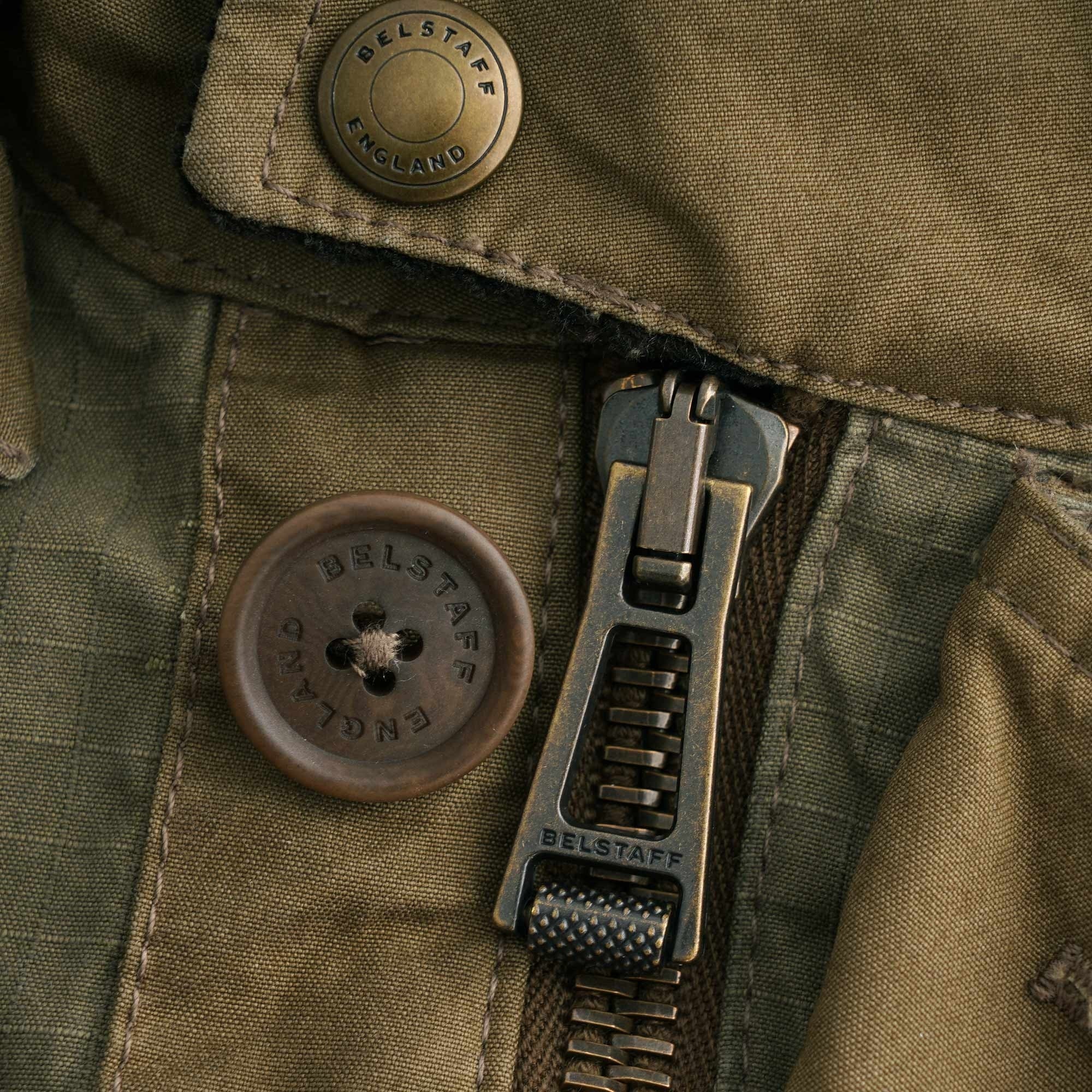 Close-up of the robust metal zipper and branded button on the Belstaff Fieldmaster Jacket.