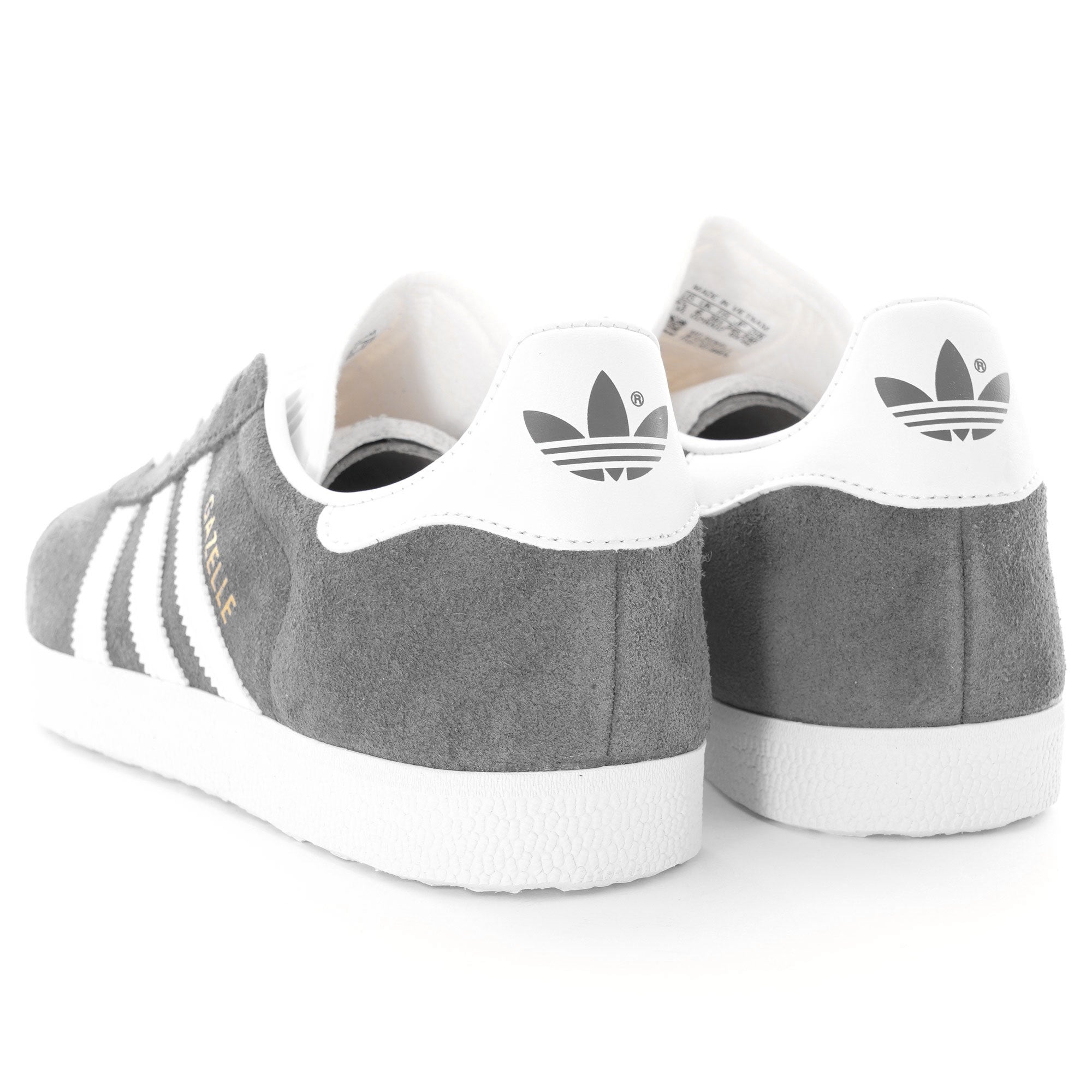 Rear view of two grey Adidas Gazelle trainers showing the white heel tab and logo.