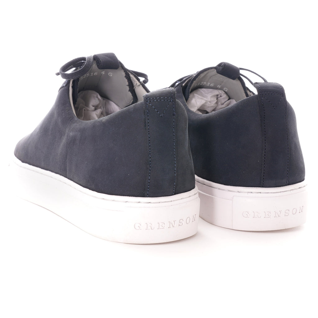 Rear view of two dark blue shoes with white soles, showing the brand name.