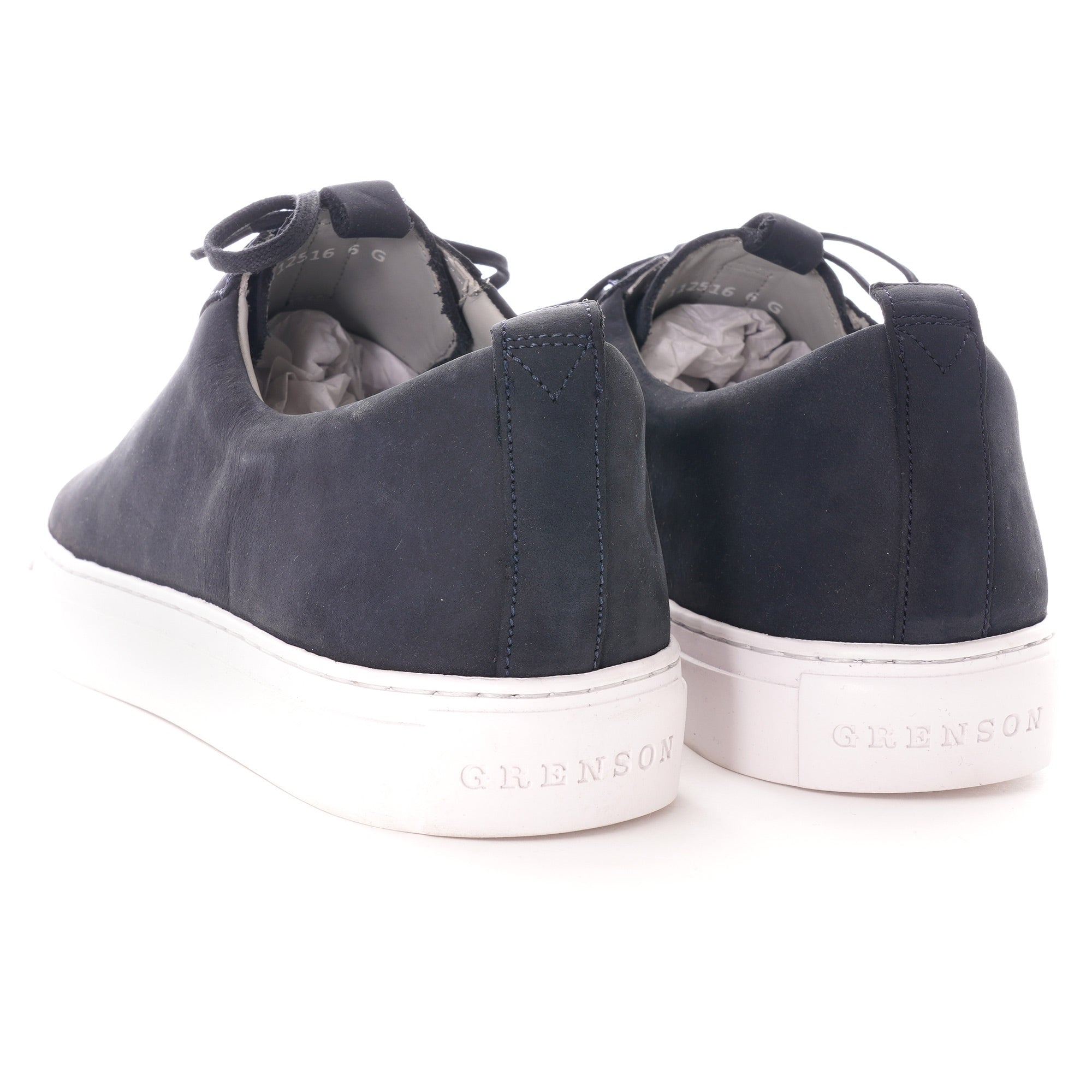 Rear view of two dark blue shoes with white soles, showing the brand name.