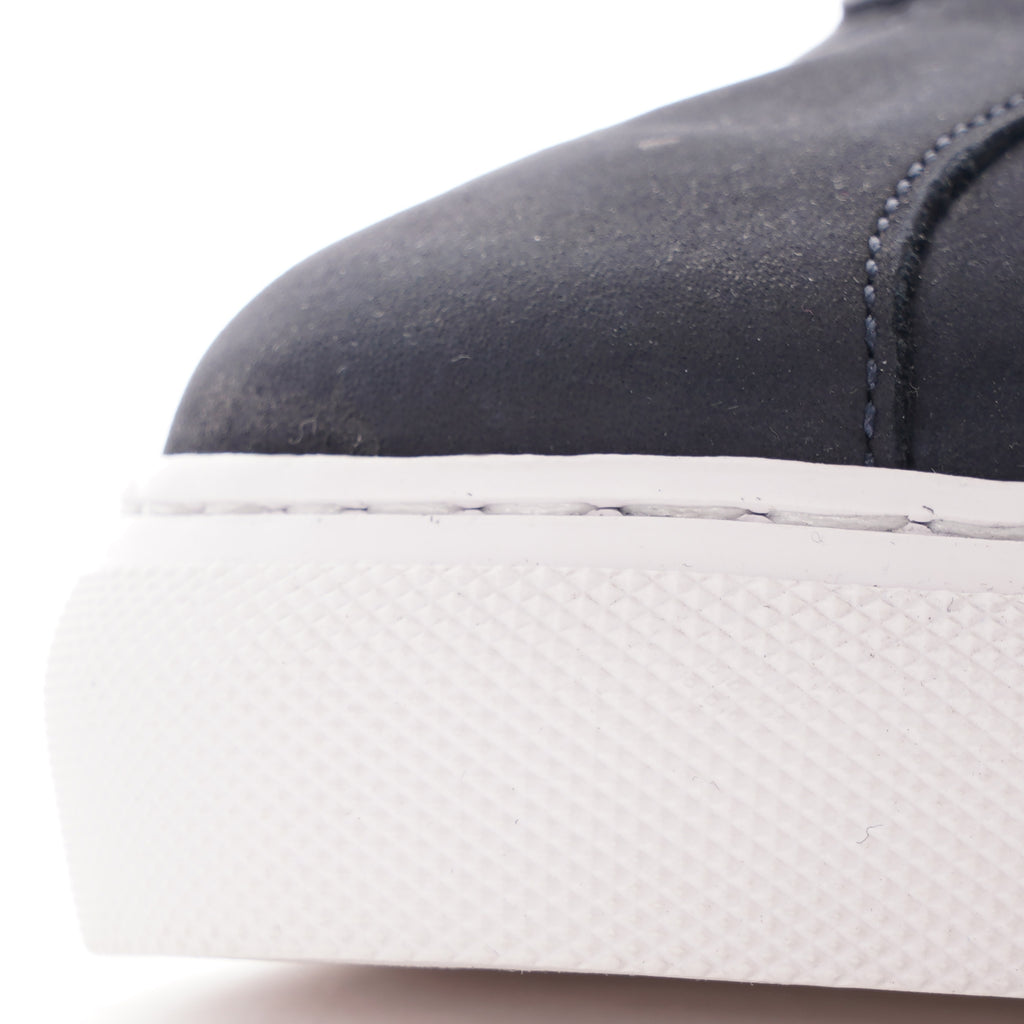 Close-up of the textured white sole and dark blue upper of a casual shoe.