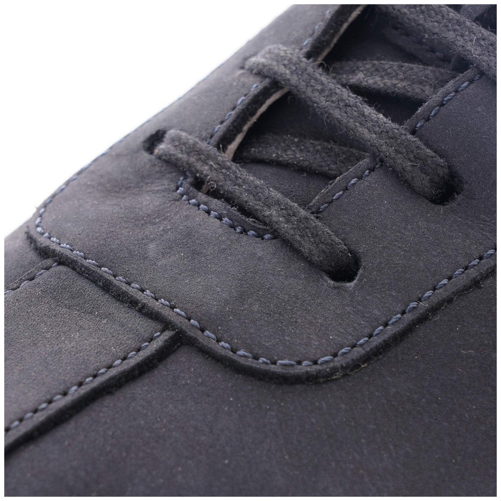 Close-up of the dark blue laces and stitching on a stylish casual shoe.