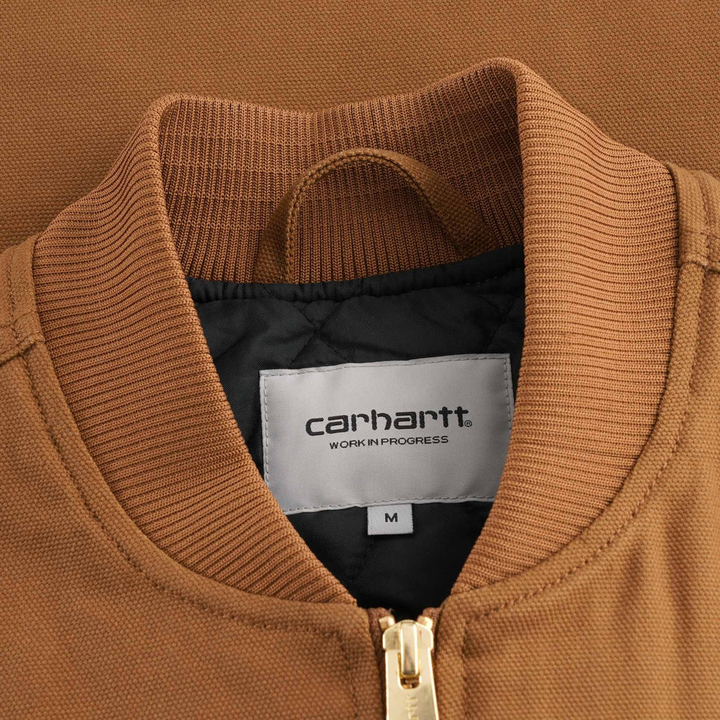Close-up of the Carhartt WIP label on the collar of the brown vest, showing size M.