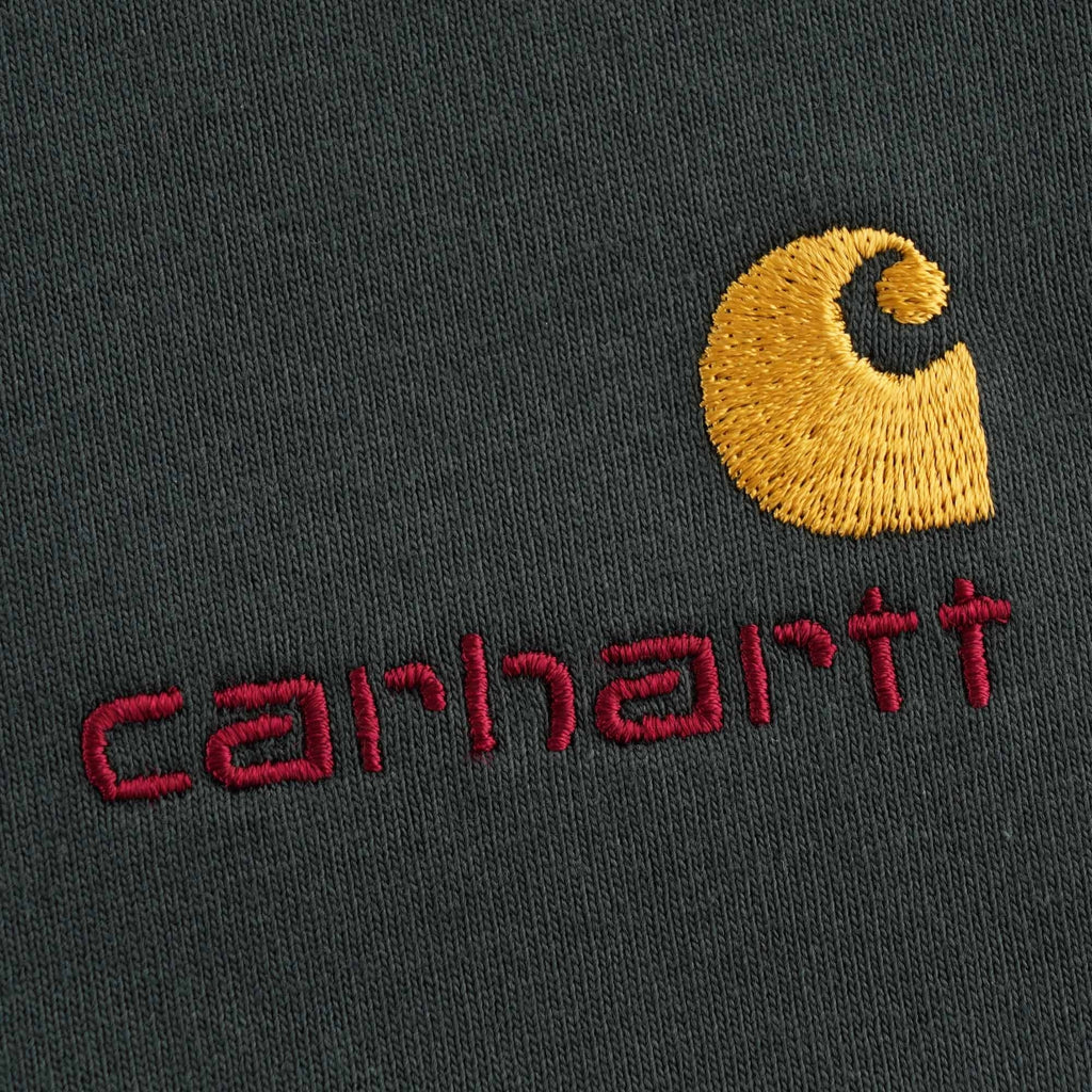 A detailed view of the embroidered Carhartt 'C' logo and red brand name on the t-shirt.